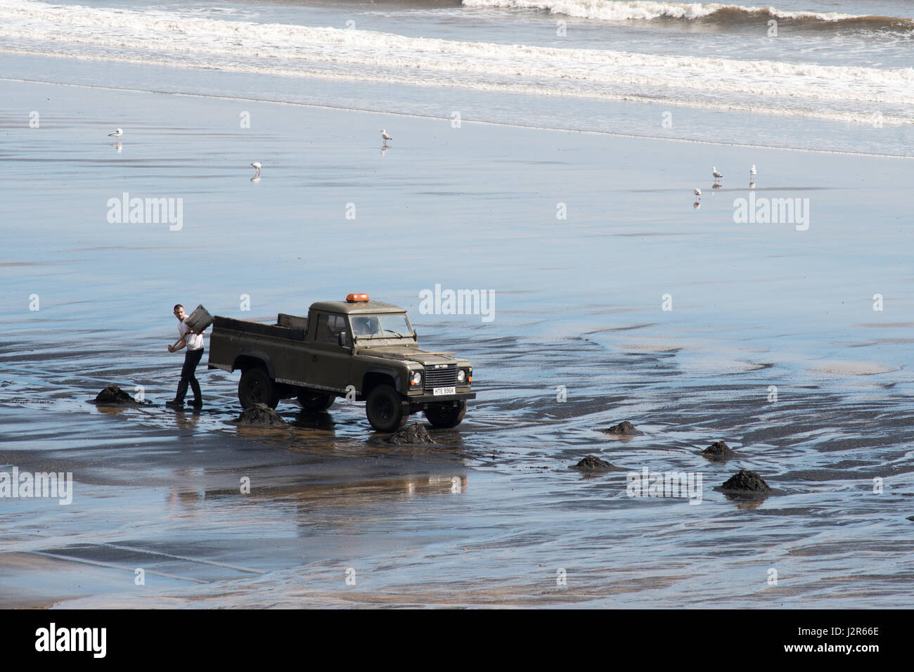 Man collecting sea coal at Seaton Carew, Hartlepool, England, UK Stock Photo