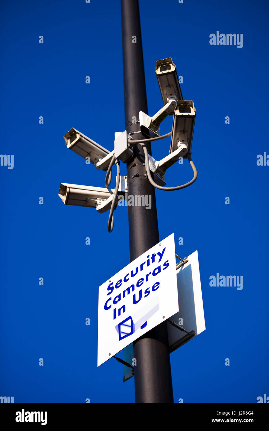 Lamppost on site parking facilities with security cameras aimed in different directions and information inscription Security Cameras in use for safety Stock Photo