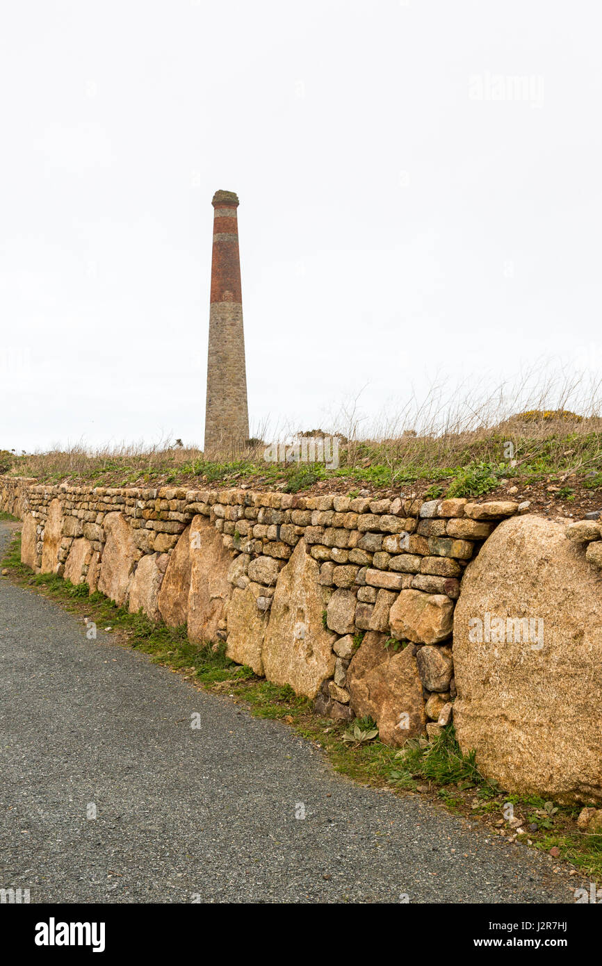 A decorative granite dry stone wall and disused tin mine chimney at Botallack, Cornwall, England Stock Photo