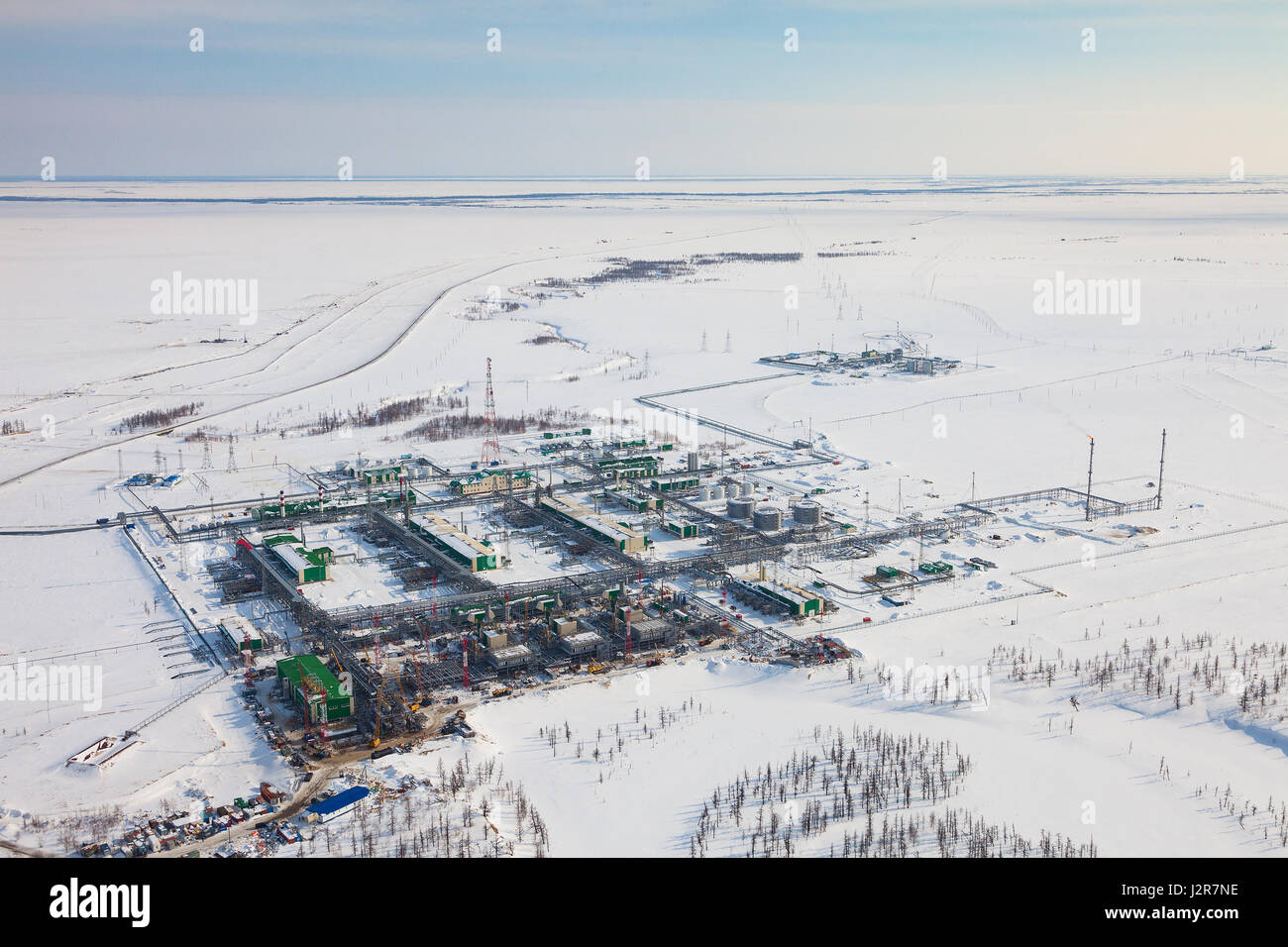 Oil and gas industry. Oil pump jack station in a oil field in tundra. Petrochemical object in West Siberia. Stock Photo