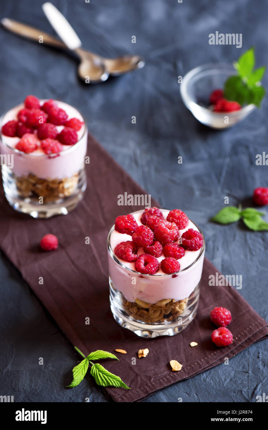 Homemade organic fresh parfait dessert with raspberries and granola, selective focus Stock Photo
