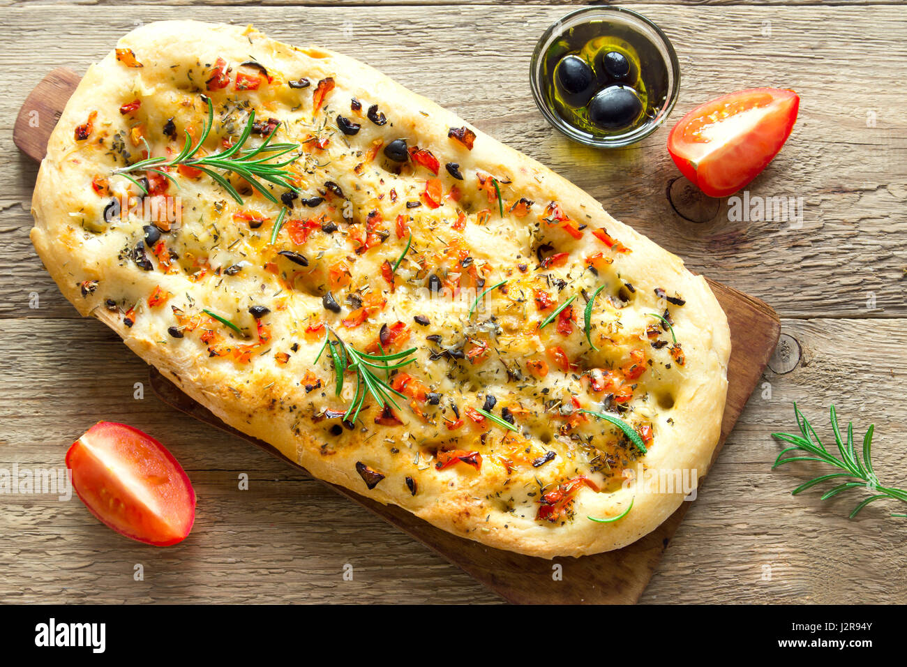 Traditional Italian Focaccia with tomatoes, black olives and rosemary
