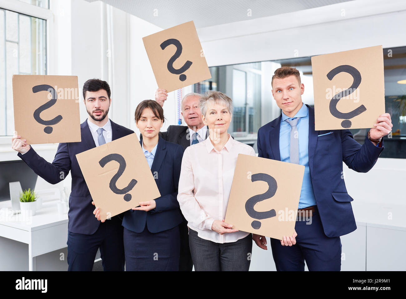 Business team holds question marks for doubt Stock Photo