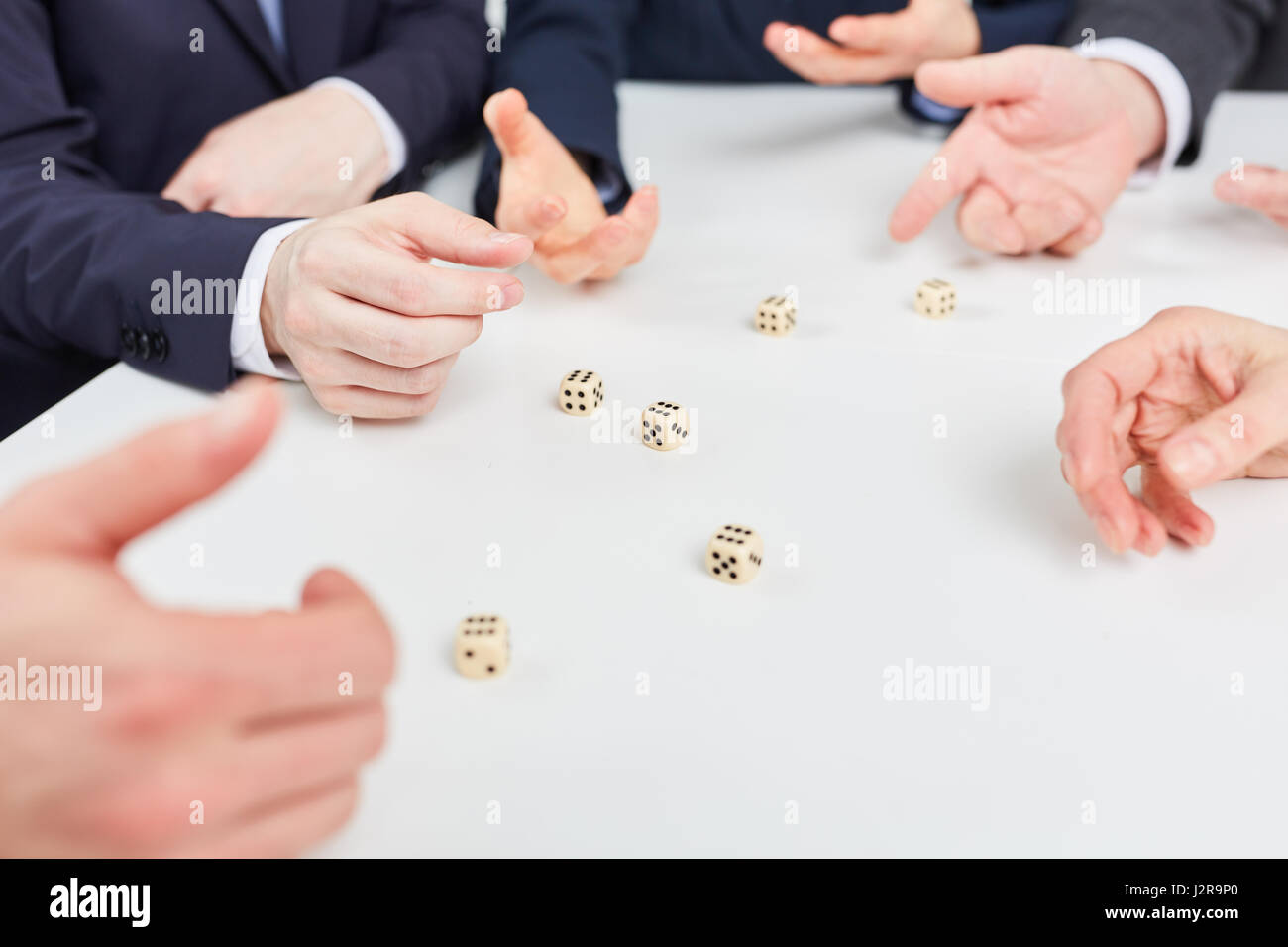 Hands playing roll the dice game as business team building exercise Stock Photo