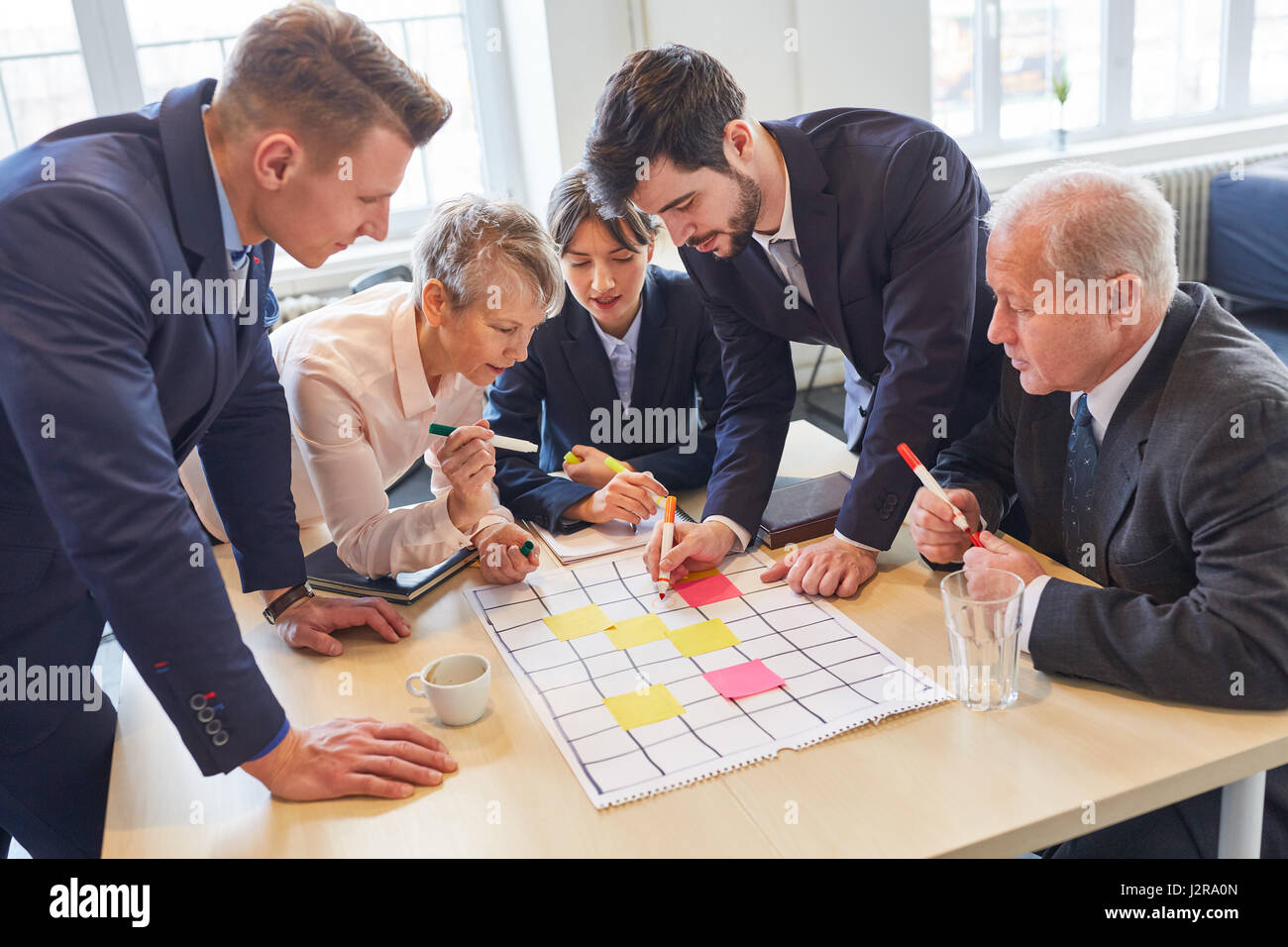 Business team in creative teambuilding workshop with colorful notes ...