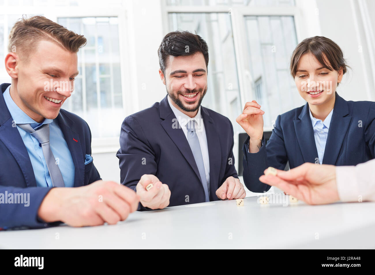 Business people playing dice game in team building creative workshop Stock Photo