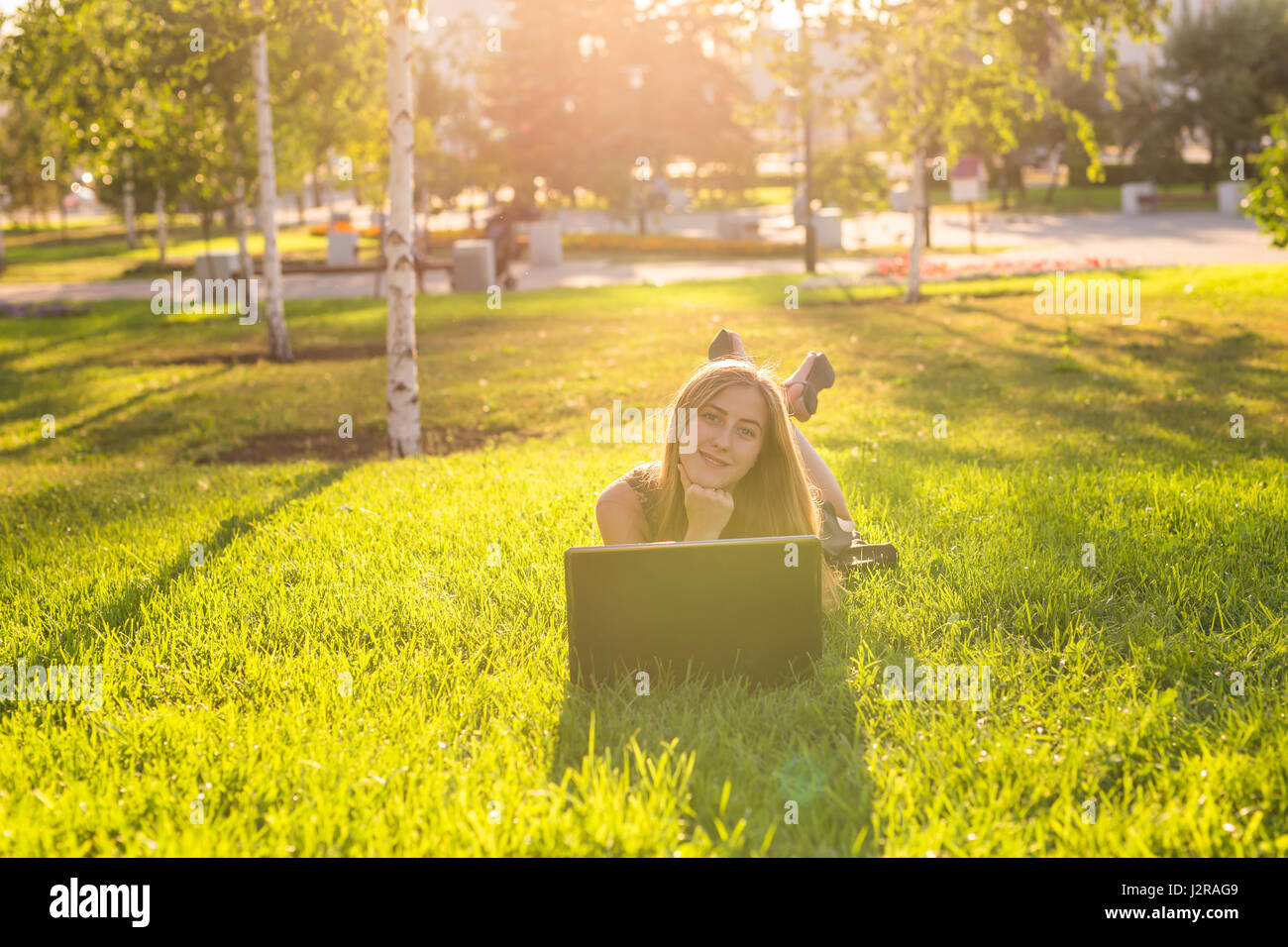 girl lying on the grass with laptop Stock Photo - Alamy