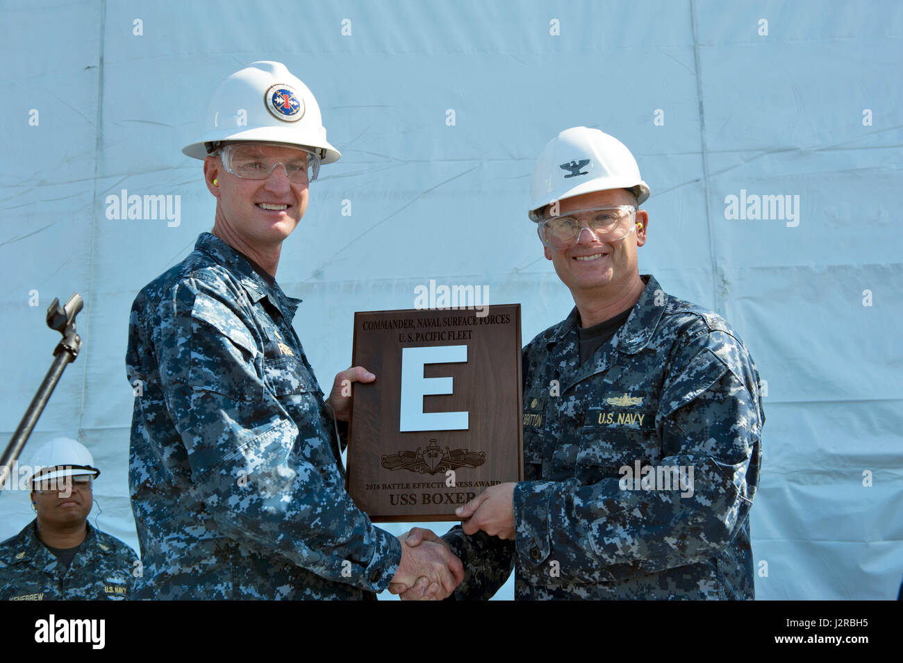 170421-N-UB927-027 SAN DIEGO (April 21, 2017) Capt. Patrick Foege, commander, Amphibious Squadron 1, presents Capt. Benjamin Albritton, commanding officer of amphibious assault ship USS Boxer (LHD 4) with the 6th consecutive Battle Effectiveness, or ‘Battle E,’ award during an all-hands call. Boxer is at it's homeport undergoing a phased maintenance availability. (U.S. Navy photo by Mass Communication Specialist 3rd Class Brett A. Anderson/Released) Stock Photo