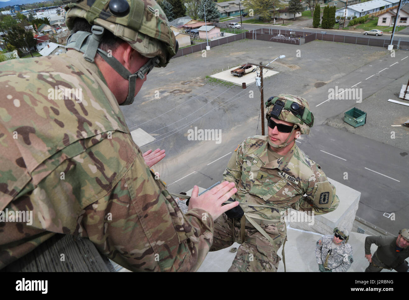 U.S. Army 1st Lt. Thomas Suddes, 756th Ordnance Company (EOD), 184th Ordnance Disposal Battalion (EOD), 52nd Ordnance Group (EOD), receives instructions before lowering himself during a vertical access training exercise at Yakima Fire Station 95, Yakima, Wash., April 25, 2017. The vertical access training is designed to create adaptive leaders capable of solving various threats in hostile and friendly environments. (U.S. Army photo by Sgt. Kalie Jones) Stock Photo