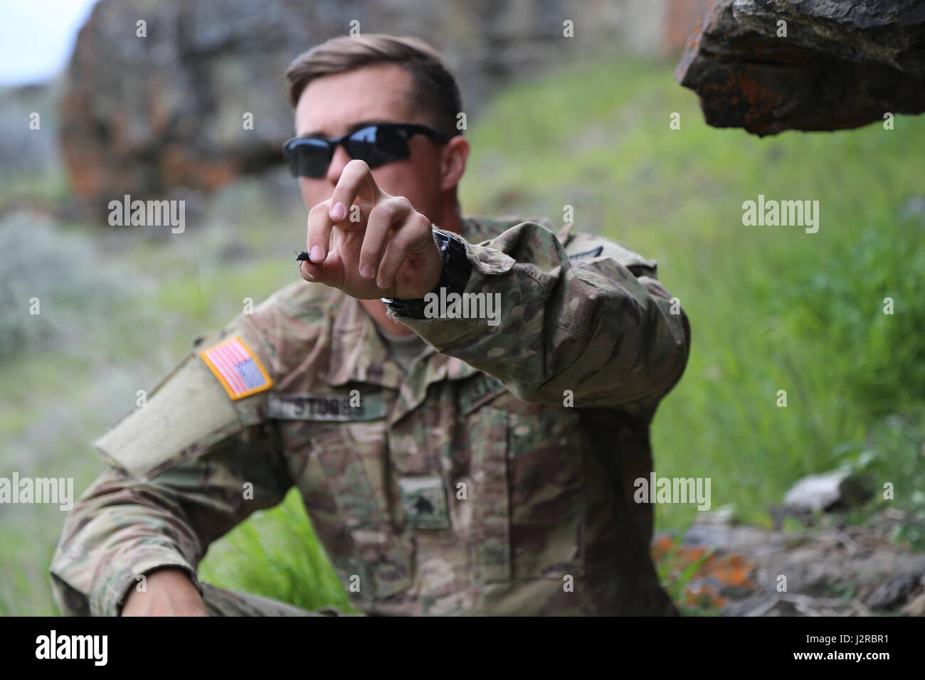 U.S. Army Sgt. Brandon Stubbs, 756th Ordnance Company (EOD), 184th Ordnance Battalion (EOD), 52nd Ordnance Group (EOD), holds a beetle that he found during a Survival, Evasion, Resistance, and Escape class at the Yakima Training Center, Yakima, Wash., April 25, 2017. Soldiers from 20th CBRNE Command's survival training focused on the five basic needs for desert conditions. (U.S. Army photo by Sgt. Kalie Jones) Stock Photo