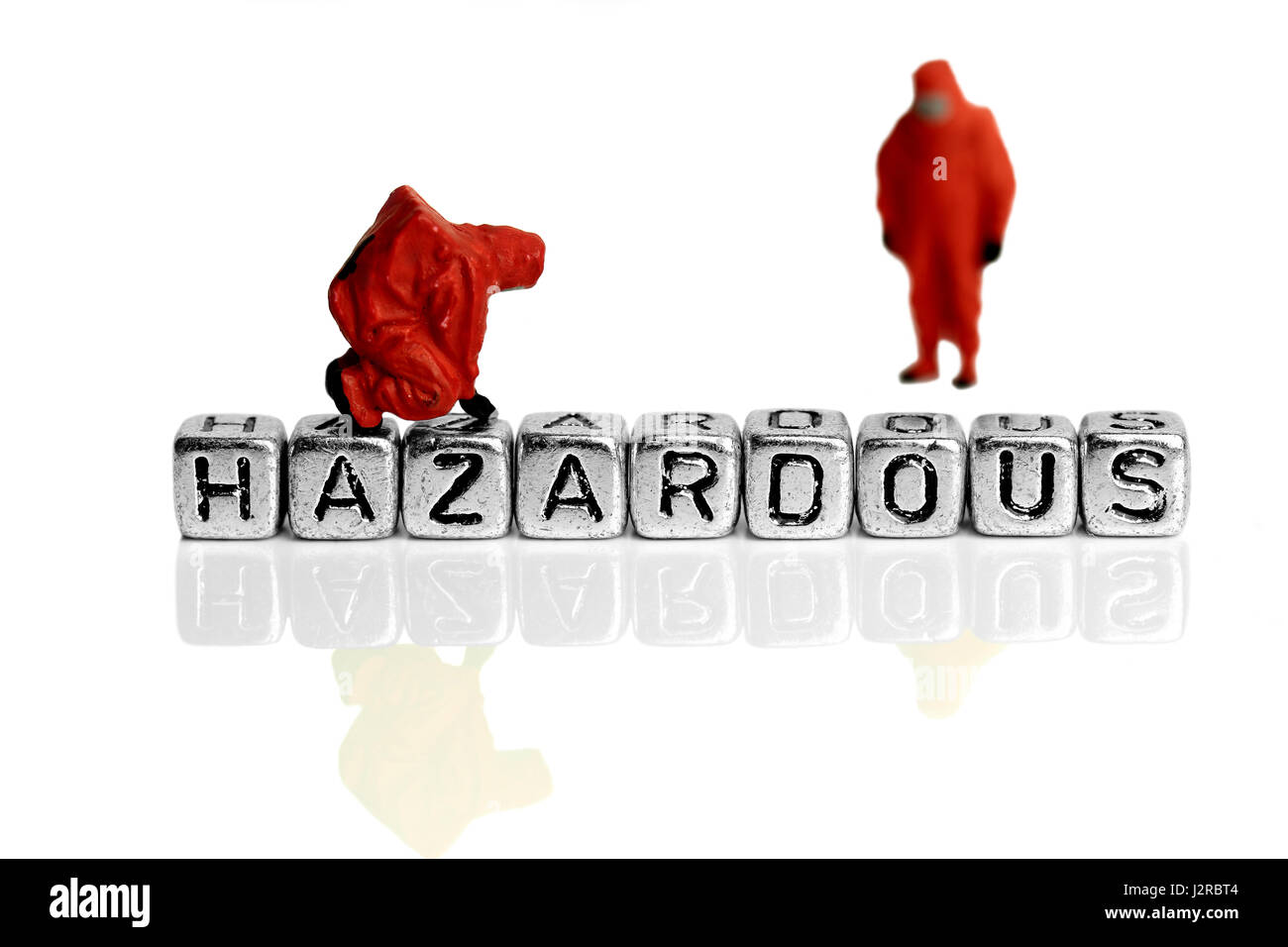 Miniature scale model team in chemical suits with the word hazardous on beads Stock Photo