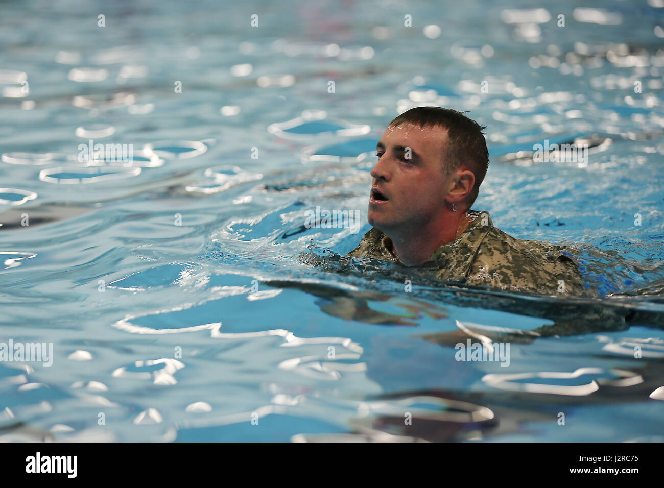 U.S. Army Sgt. Anthony Barba, 184th Headquarters and Headquarters Detachment (EOD), 184th Ordnance Disposal Battalion (EOD), 52nd Ordnance Group (EOD), stops to catch his breath during the 100 meter swim portion of the German Armed Forces Proficiency Badge (GAFPB) at Central Washington University, Ellensburg, Wash., April 23, 2017. The GAFPB swim requires participants to swim in uniform, without boots, for 100 meters in under four minutes, then remove the uniform in the deep end without holding the edges of the pool. (U.S. Army photo by Sgt. Kalie Jones) Stock Photo