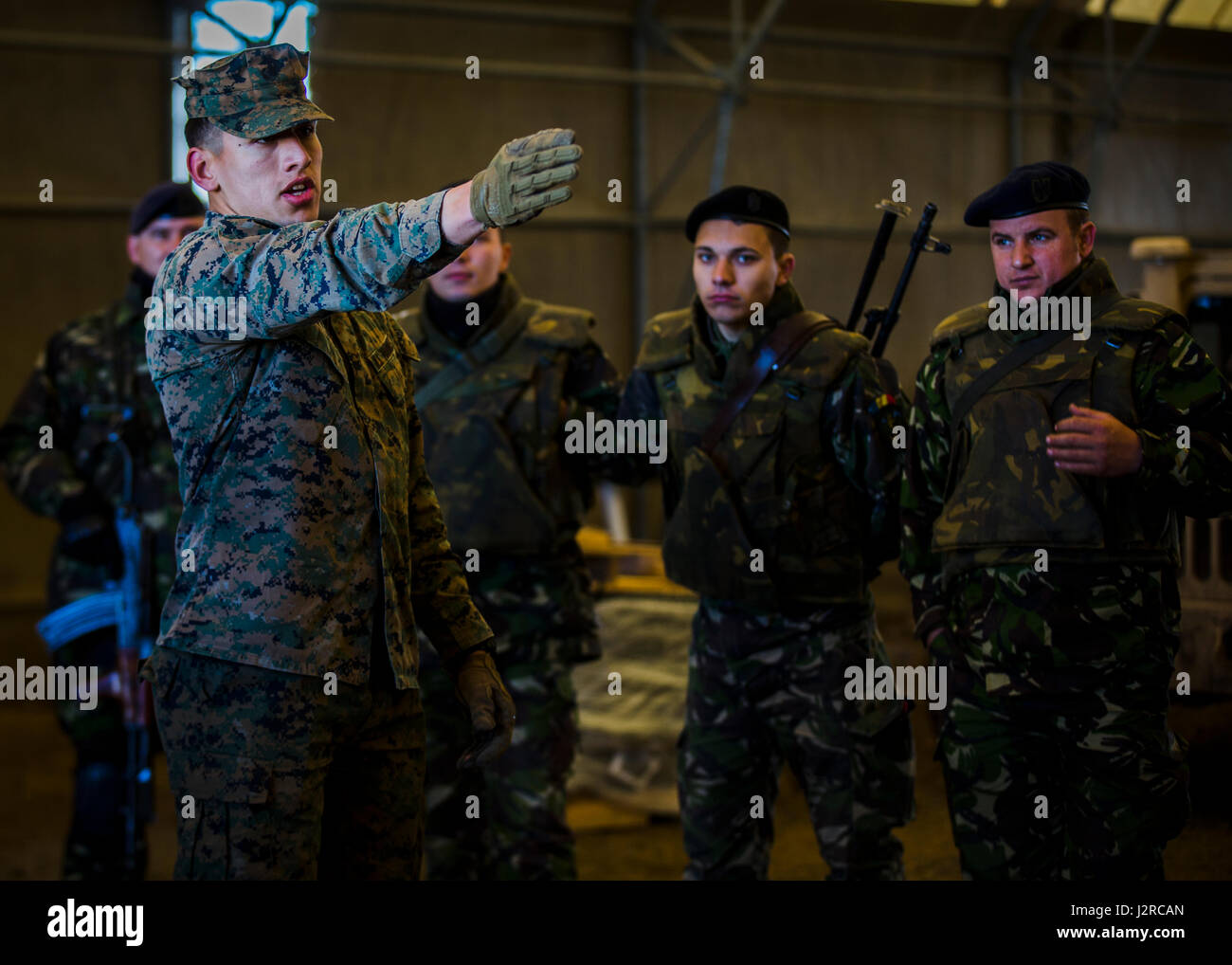U.S. Marine Cpl. Eduardo Duran-Espino, a rifleman with Marine Rotational Force Europe 17.1, gives a hand-and-arm signal class with Romanian soldiers at Babadag Training Area, Romania, April 24, 2017. Marines trained with Romanian soldiers and other Allies during Exercise Platinum Eagle 17.2 to improve interoperability. Partnerships formed from multilateral exercises like this are crucial in dealing with regional issues and keeping peace in the Eastern European region. (U.S. Marine Corps photo by Lance Cpl. Sarah N. Petrock) Stock Photo