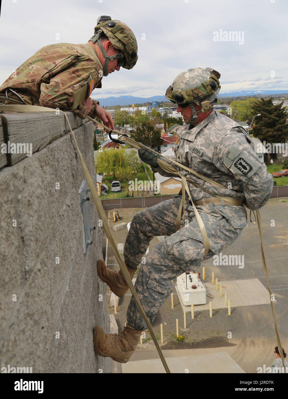 U.S. Army Sgt. Anthony Barba, 184th Headquarters and Headquarters Detachment (EOD), 184th Ordnance Disposal Battalion (EOD), 52nd Ordnance Group (EOD), prepares to lower himself during a vertical access training exercise at Yakima Fire Station 95, Yakima, Wash., April 25, 2017. The vertical access training is designed to create adaptive leaders capable of solving various threats in hostile and friendly environments. (U.S. Army photo by Sgt. Kalie Jones) Stock Photo