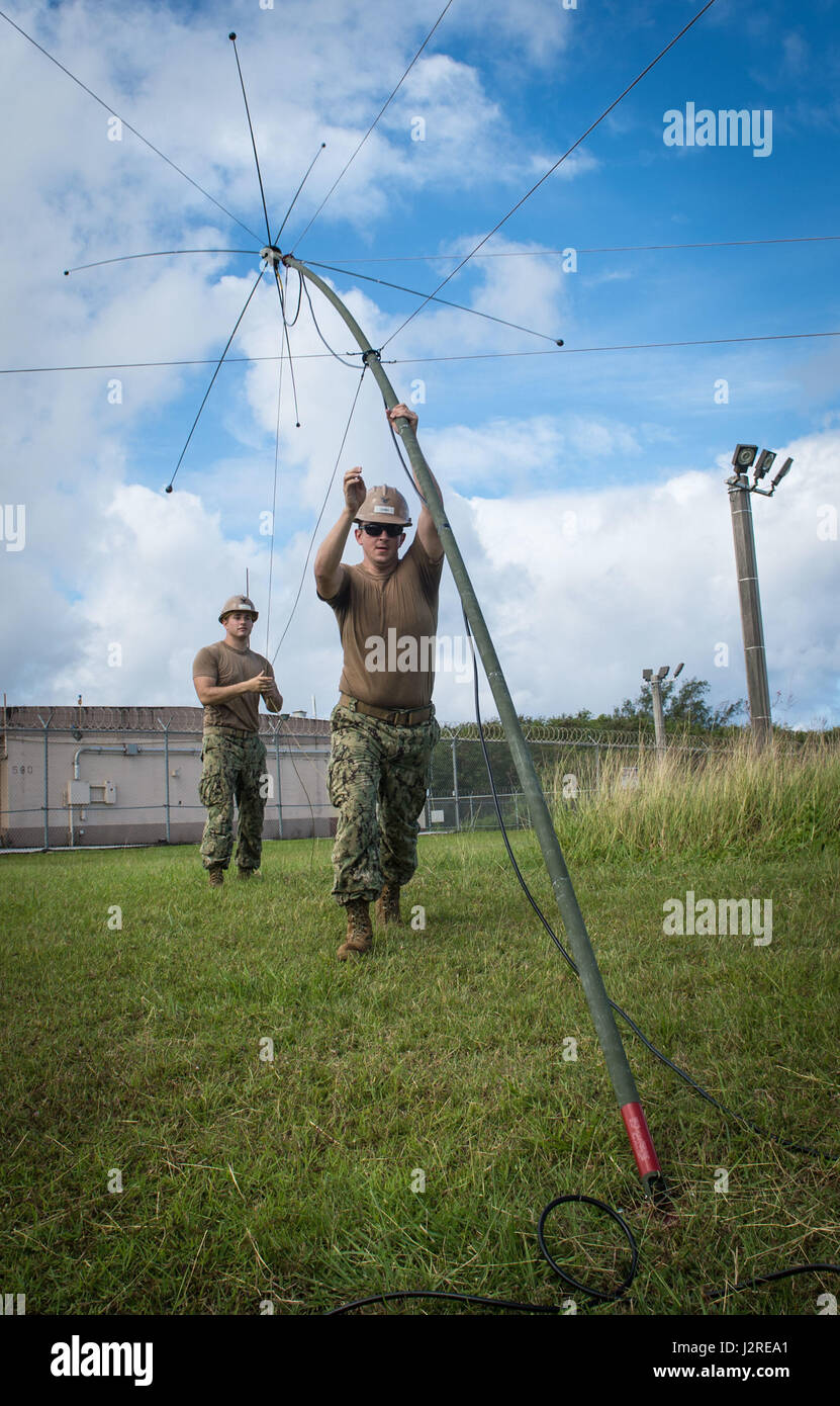 Electronics Technician 3rd Class Anthony Juarez and Construction Electrician 2nd Class Kevin Aquirre, both assigned to Naval Mobile Construction Battalion 1 (NMCB 1) Detachment Guam, hoist an AT-420 antenna at Naval Base Guam April 25, 2017.  AT-420s utilize ultra high frequency (UHF) and very high frequencies (VHF) to increase communication abilities. NMCB 1 Detachment Guam is a Commander, Task Force 75 unit that provides expeditionary construction and engineering support to expeditionary bases and responds to humanitarian assistance disaster relief requests. (U.S. Navy Combat Camera Photo by Stock Photo