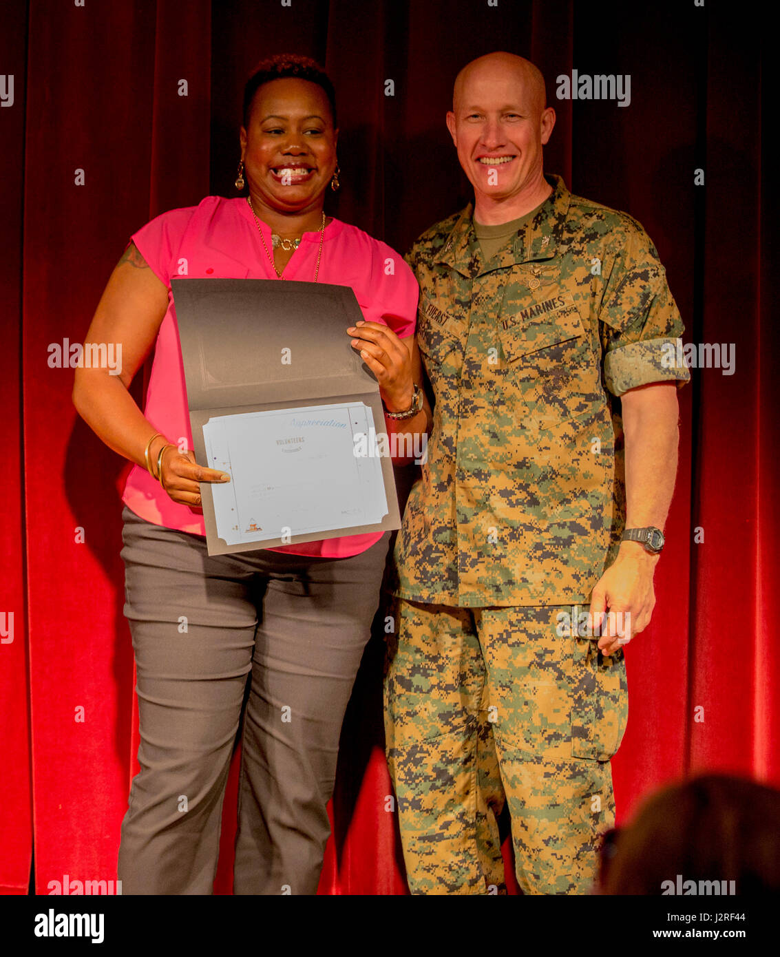 Carla Bates, a volunteer with the Girl Scouts of the United States of America, receives an award from U.S. Marine Corps Col. Richard F. Fuerst, commanding officer of Marine Corps Air Station Iwakuni, during the 8th Annual Installation Volunteer Ceremony at MCAS Iwakuni, Japan, April, 26, 2017. The event was designed to show appreciation and recognition for service members and civilians who volunteered on the installation throughout 2016. Bates was one of the top three civilians who contributed the most volunteer service hours. (U.S. Marine Corps photo by Pfc. Stephen Campbell) Stock Photo