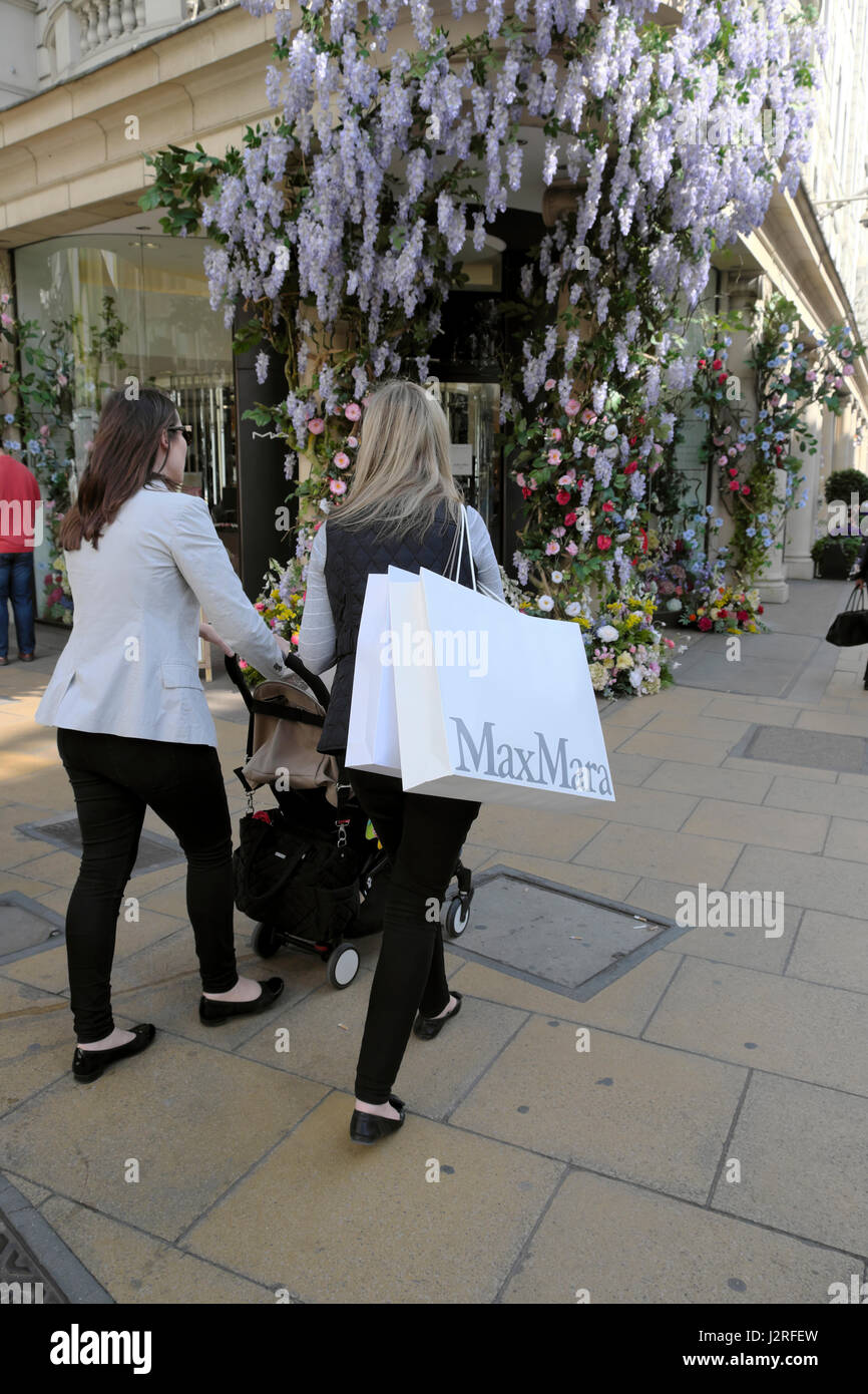 Artificial flowers with wisteria greet shoppers at the entrance of Fenwick's department store at Brook St and New Bond Street, London UK  KATHY DEWITT Stock Photo