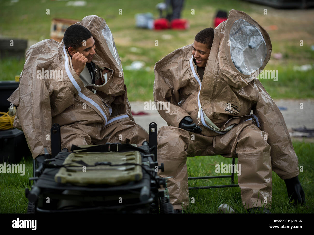 Pvt. Trae Herron and Spc. Gabriel Gomez, U.S. Army Soldiers with the 51st Chemical Biological Radiological Nuclear Company, of Fort Stewart, Georgia, joke around while wearing Level A chemical suits during Guardian Response 17 at the Muscatatuck Urban Training Center, Indiana, April 27, 2017. Guardian Response, as part of Vibrant Response, is a multi-component training exercise run by the U.S. Army Reserve designed to validate nearly 4,000 service members in Defense Support of Civil Authorities (DSCA) in the event of a Chemical, Biological, Radiological and Nuclear (CBRN) catastrophe. This yea Stock Photo