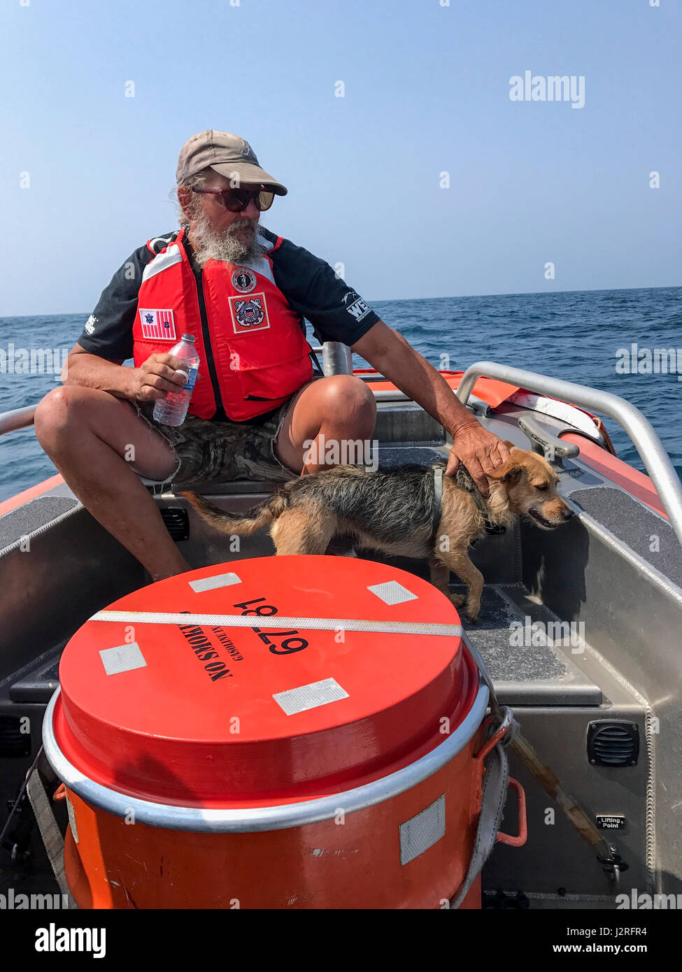 Jim Baxter, 50, and his dog, Freddy, sit on the bow of a Coast Guard ...