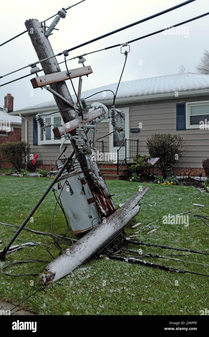 Fallen utility pole rests on the ground after spring winter storm cracks it in half in Willowick, Ohio, USA. Stock Photo