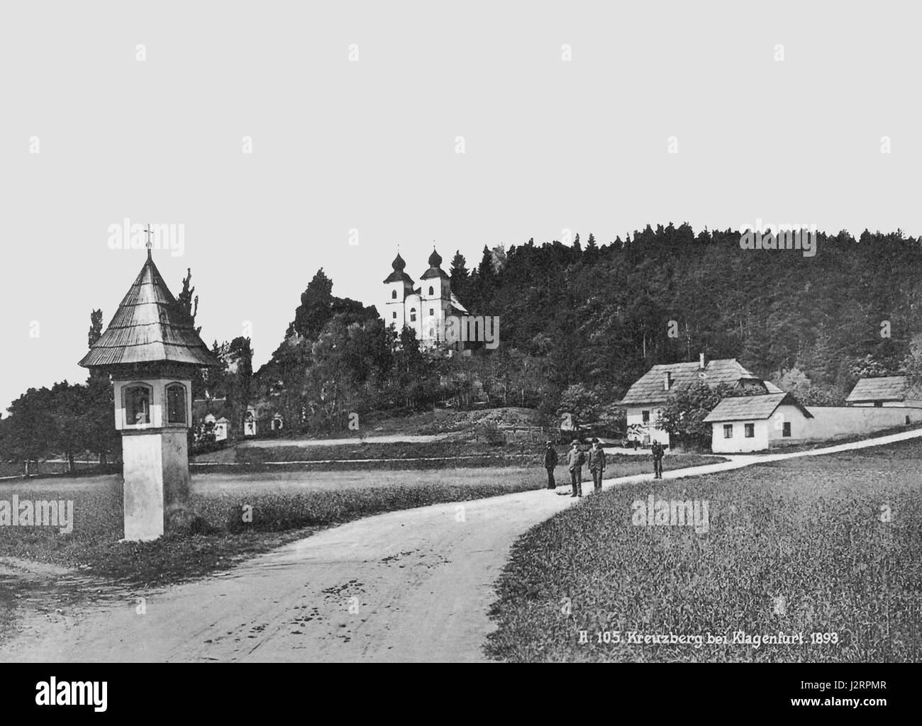 Historical photograph of the Kreuzbergl, showing a wayside shrine in the foreground, the Kreuzbergl church in the background and the restaurant 'Einsiedler' on the right side, situated in the 8th district 'Villacher Vorstadt' of the capital Klagenfurt, Carinthia, Austria Stock Photo
