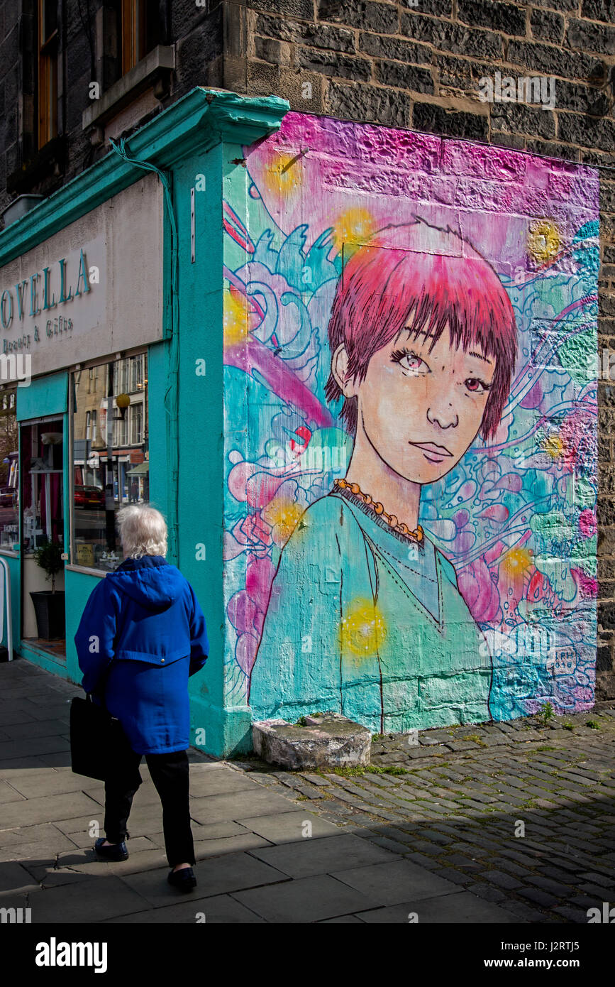 A woman walks by a piece of street art on Leith Walk, Edinburgh