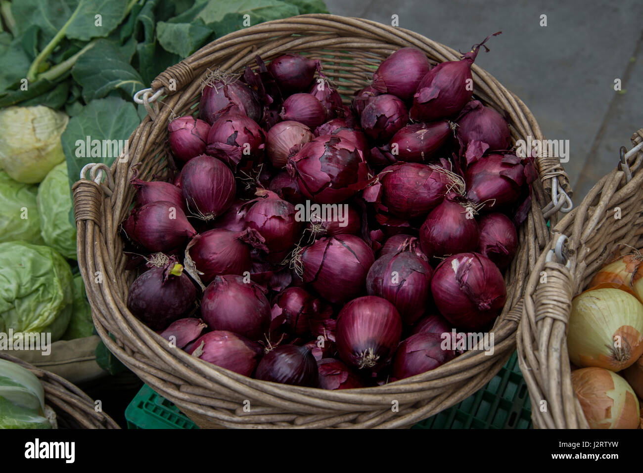 Basket of red onions at the Saturday Farmer's Market in Castle Terrace, Edinburgh, Scotland, UK. Stock Photo