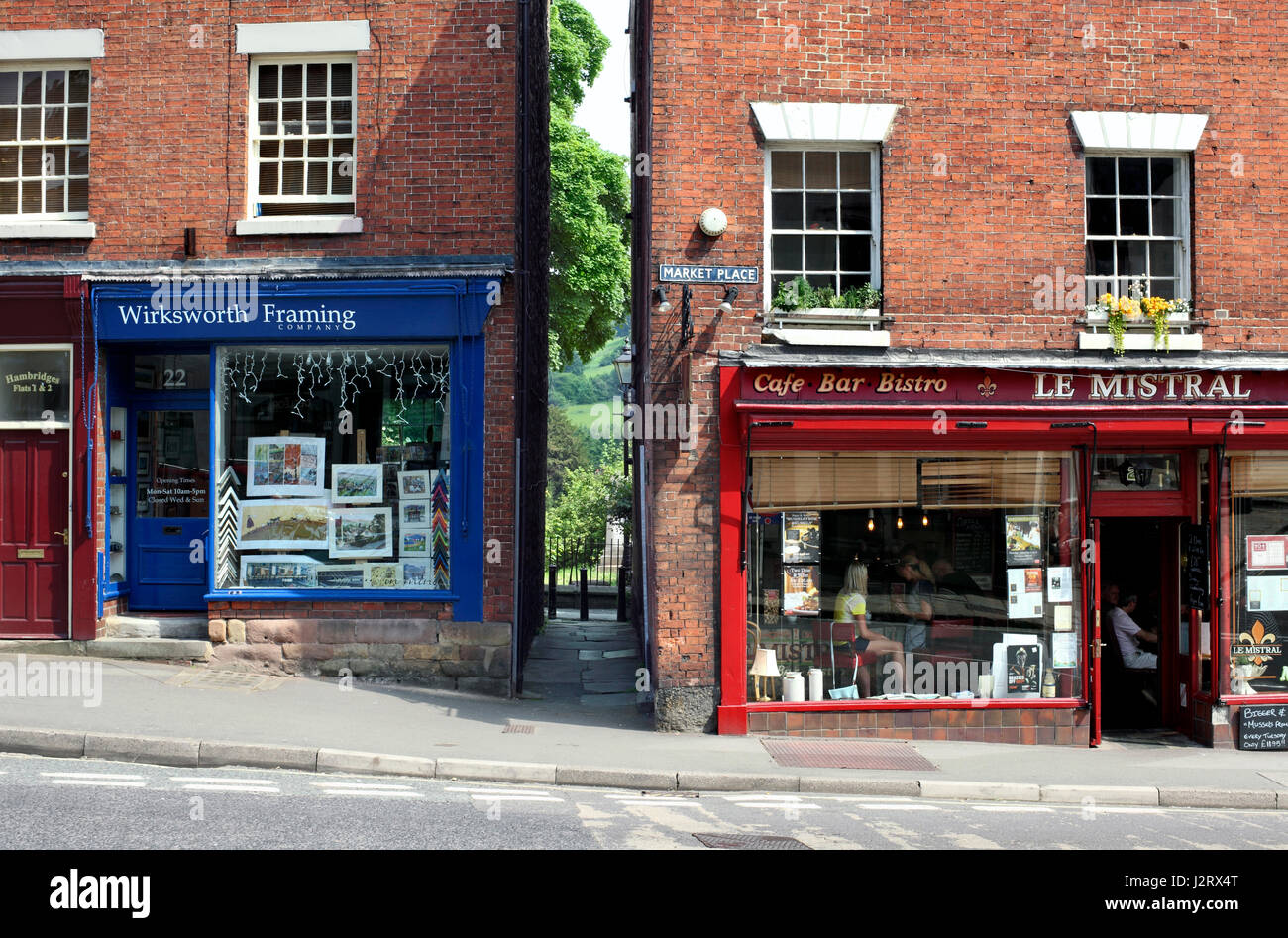 A footpath between buildings in Wirksworth's Market Place offers a glimpse of Derbyshire countryside. Stock Photo