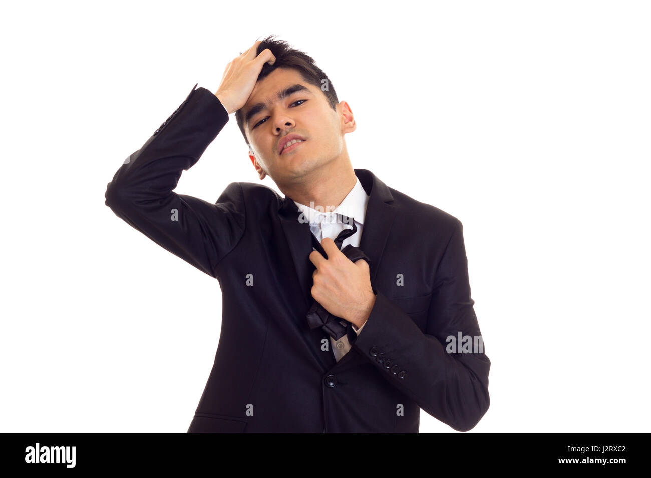 Young man in suit fixing his tie Stock Photo - Alamy
