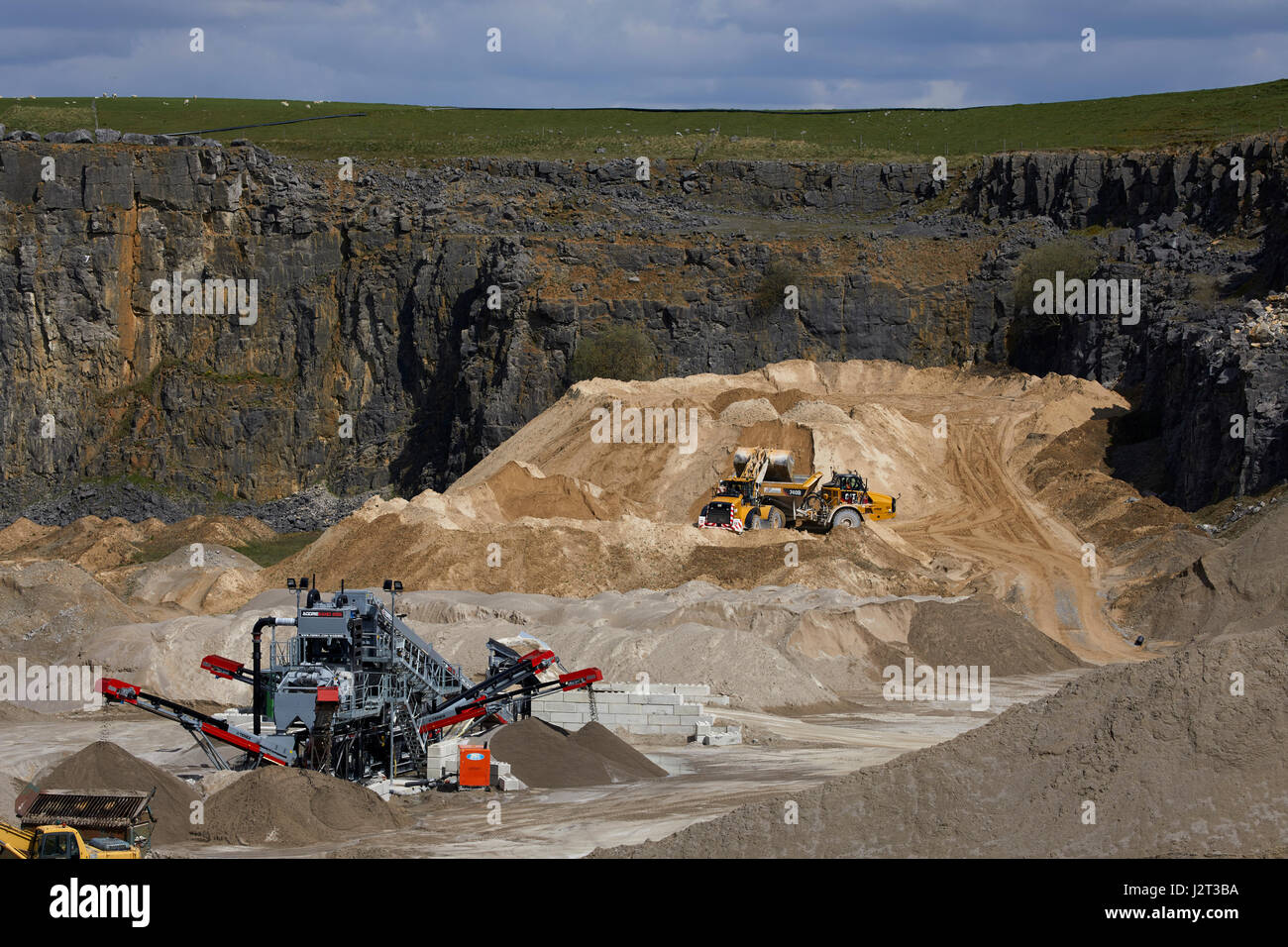 Diggers at Cemex Quarry in Dove Holes  High Peak district of Derbyshire nr Buxton. Stock Photo