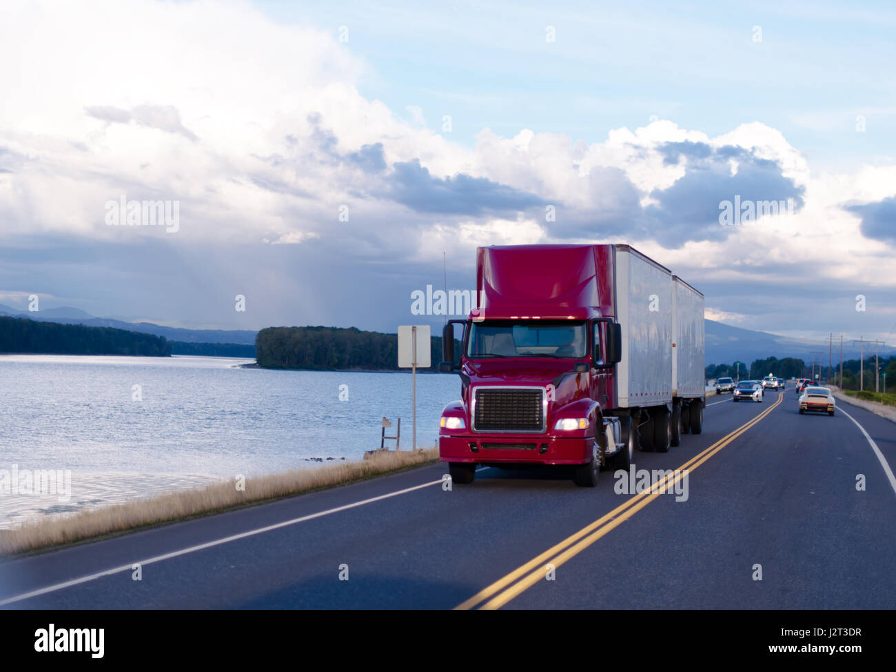 Red professional powerful truck with a spoiler and headlights pulling