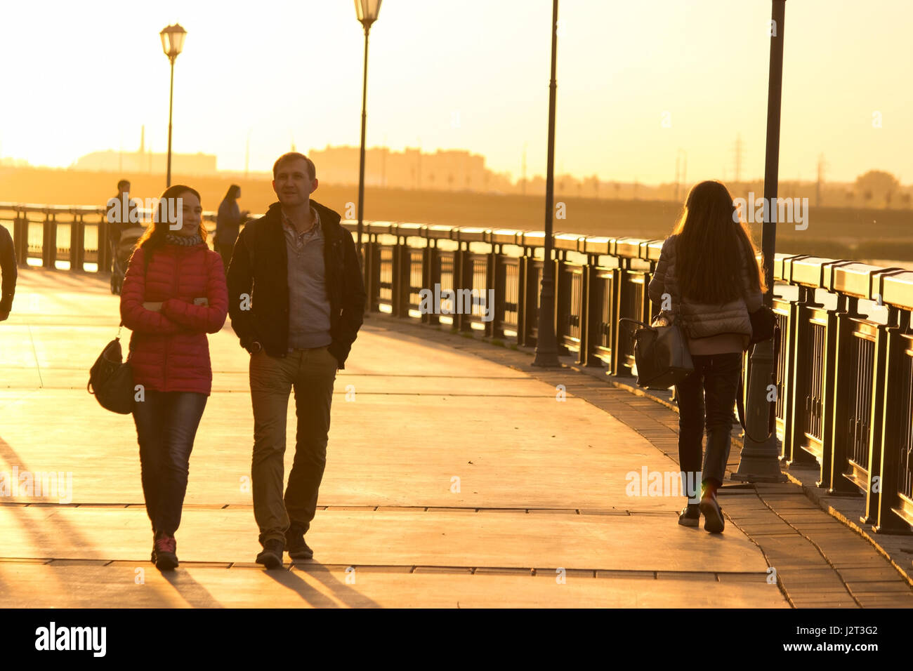 Silhouettes of people walking along the seafront promenade Stock Photo ...