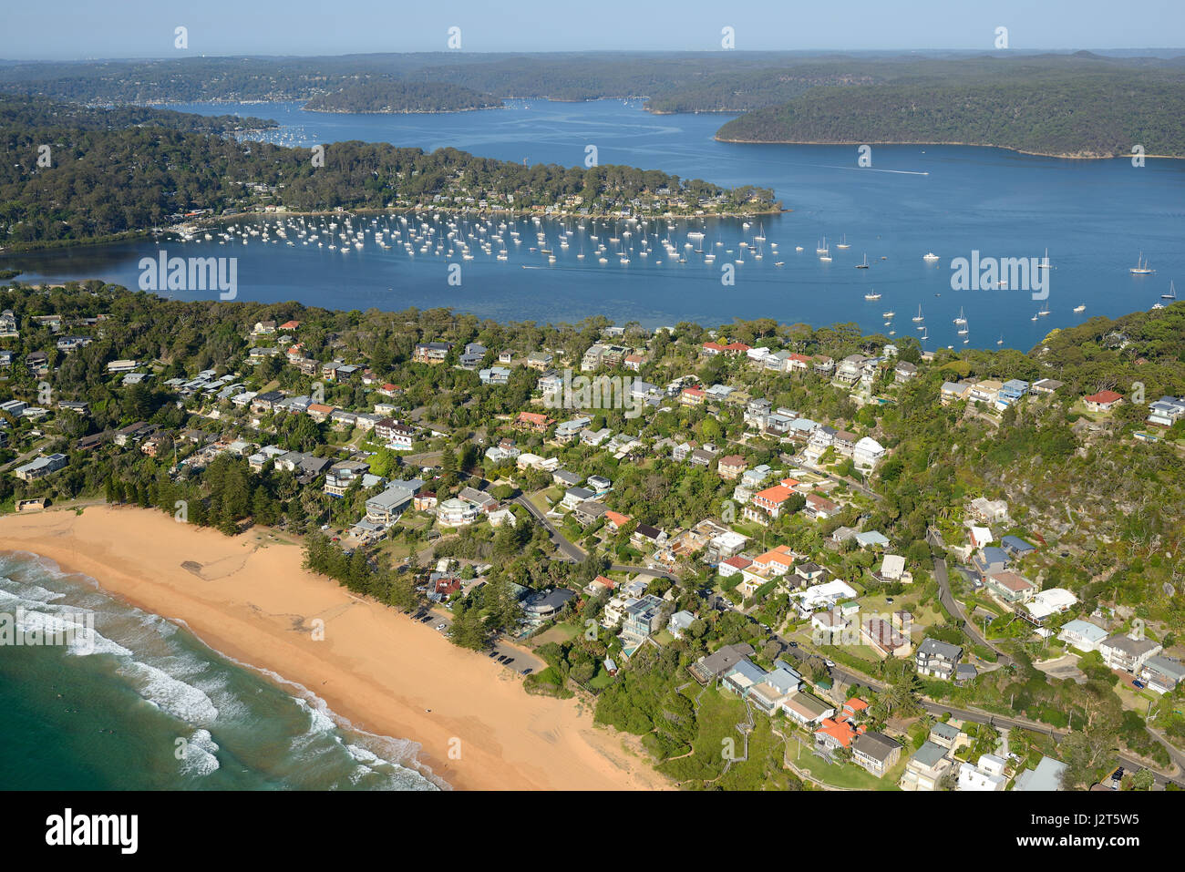 AERIAL VIEW. Beachside city between the Ocean Pacific and a ria (a drowned river valley). Whale Beach, Sydney, New South Wales, Australia. Stock Photo