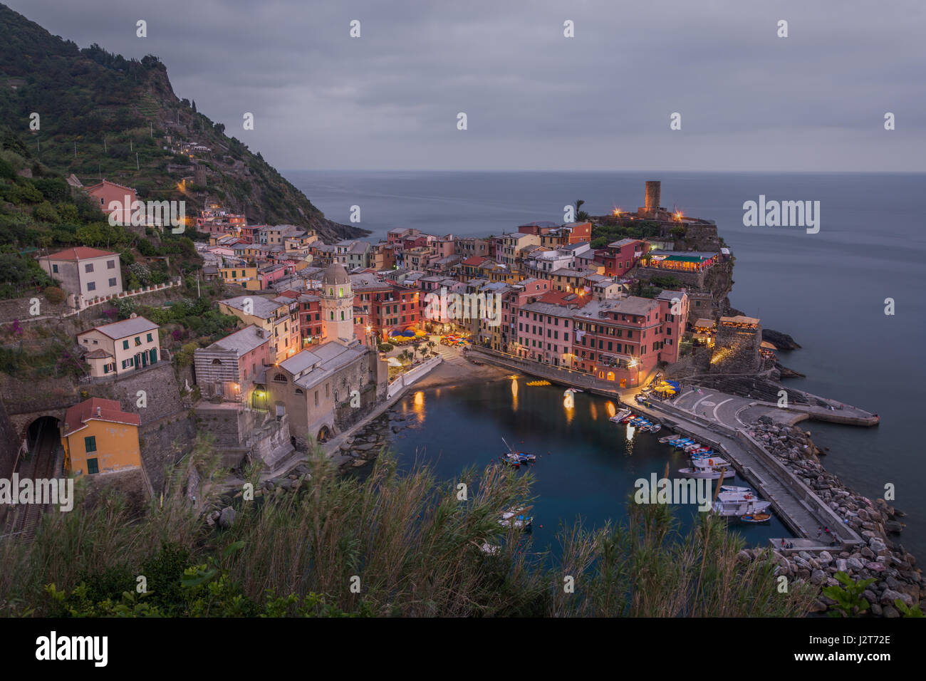 The village of Vernazza in the Cinque Terre in Liguria, Italy set against a cloudy grey sky at dusk Stock Photo