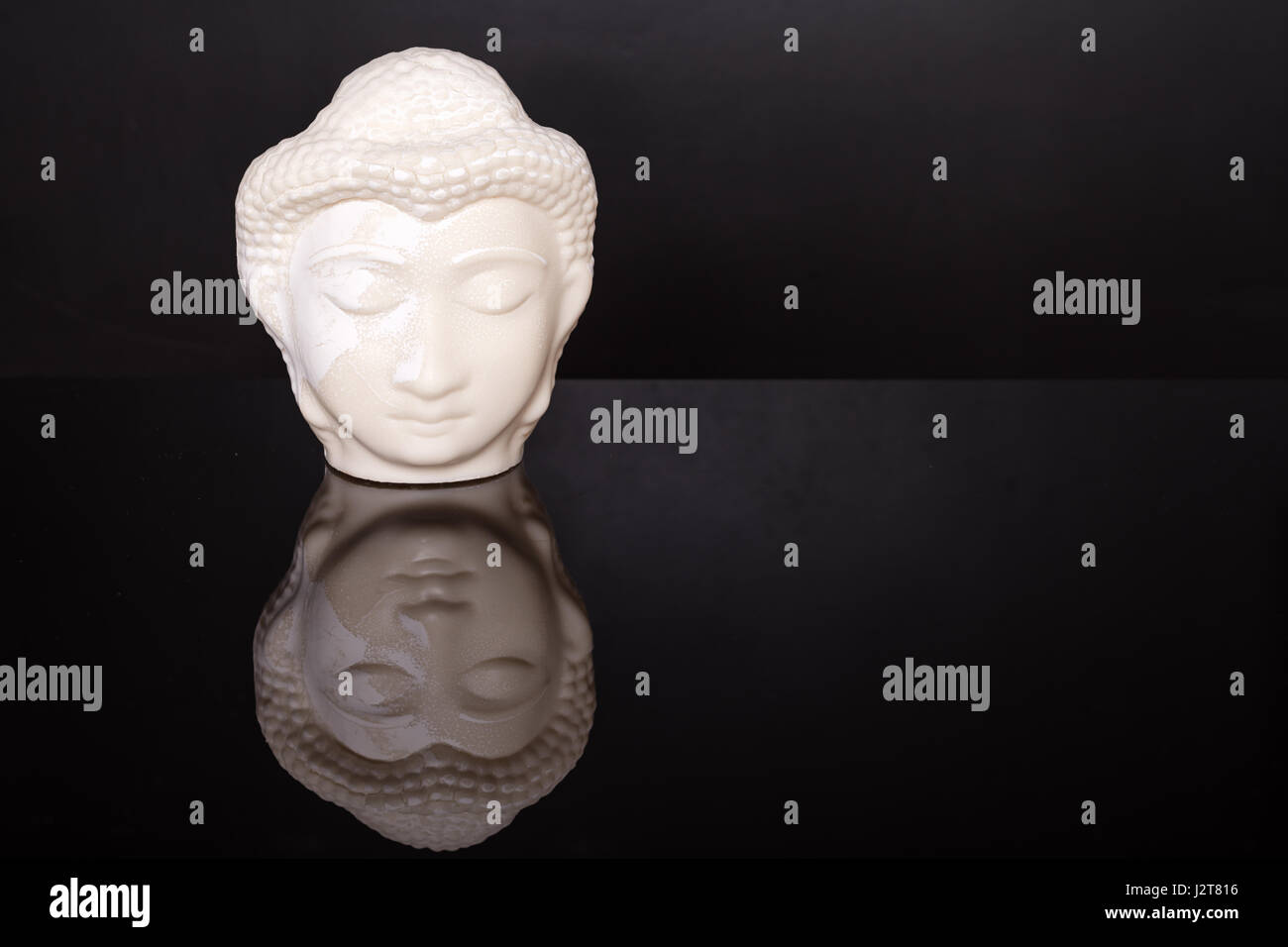 Buddha face. Buddha statue made of white marble on black background