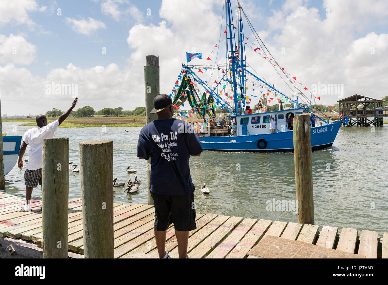 Charleston, USA. 30th Apr, 2017. People watch a decorated shrimp boat parading down Shem Creek during the annual Blessing of the Fleet signifying the start of the commercial shrimping season April 30, 2017 in Mount Pleasant, South Carolina. Coastal shrimping is part of the low country heritage but has been declining rapidly with rising costs and increased foreign competition. Credit: Planetpix/Alamy Live News Stock Photo