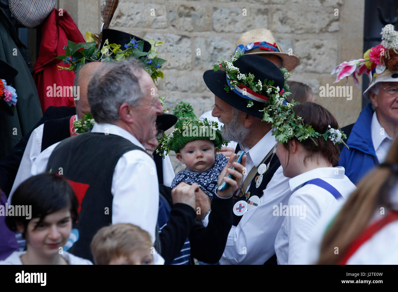 Oxford, UK. 1 May 2017. Crowds celebrate May Day in Oxford by festooning their hats with sprigs of flowers such as hawthorn. Whole families enjoy the festivities, from babies to grandparents. Crowds celebrate May morning in Oxford by watching the Morris men dance in front of Hertford College's Bridge of Sighs with the sun rising behind the bridge. May morning is traditionally celebrated in Oxford with a choir singing from the top of Magdalen College Tower after which the crowds are lead through the streets by Morris men who perform at various sites throughout the city. Stock Photo