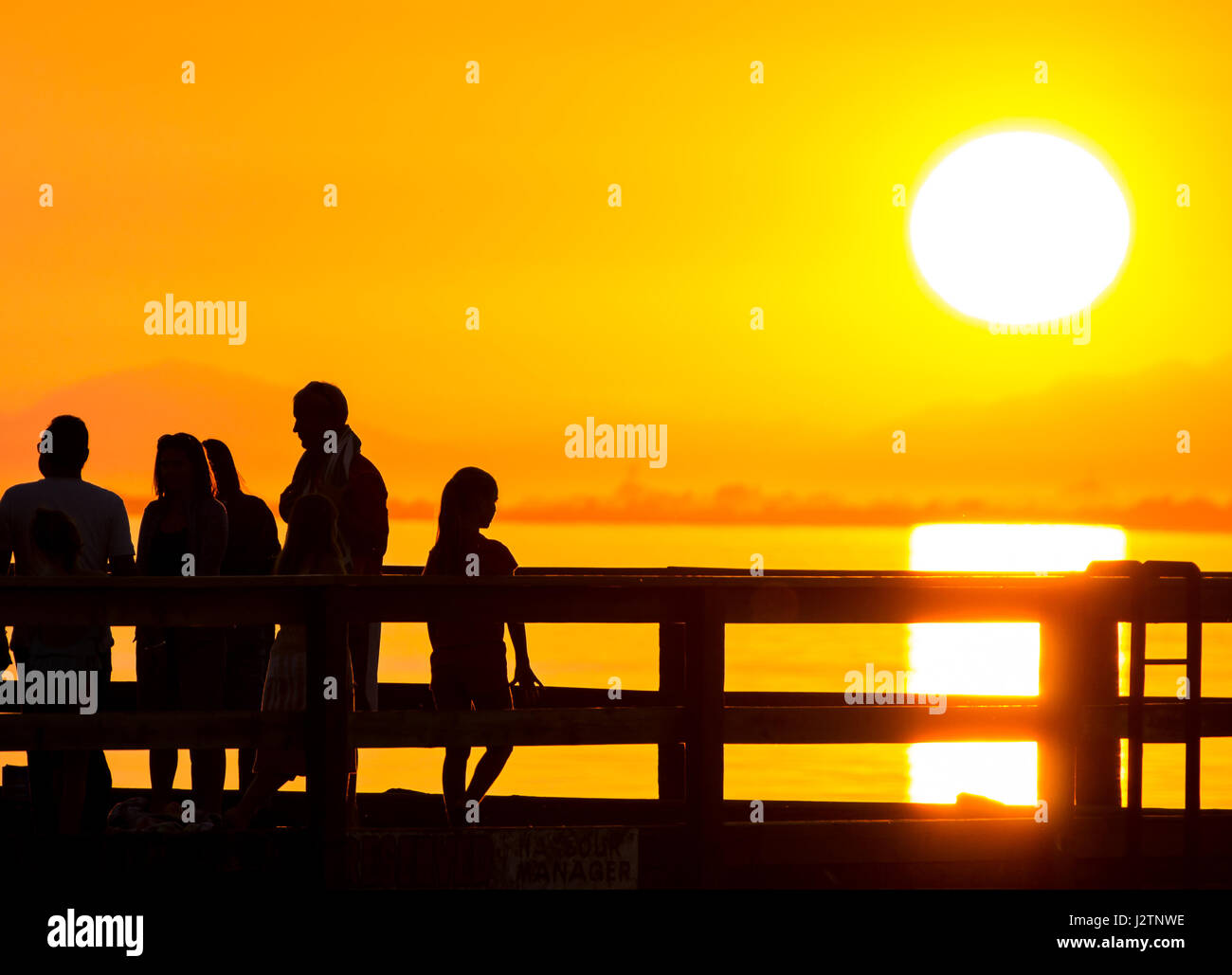 silhouette of child watching sun set Stock Photo