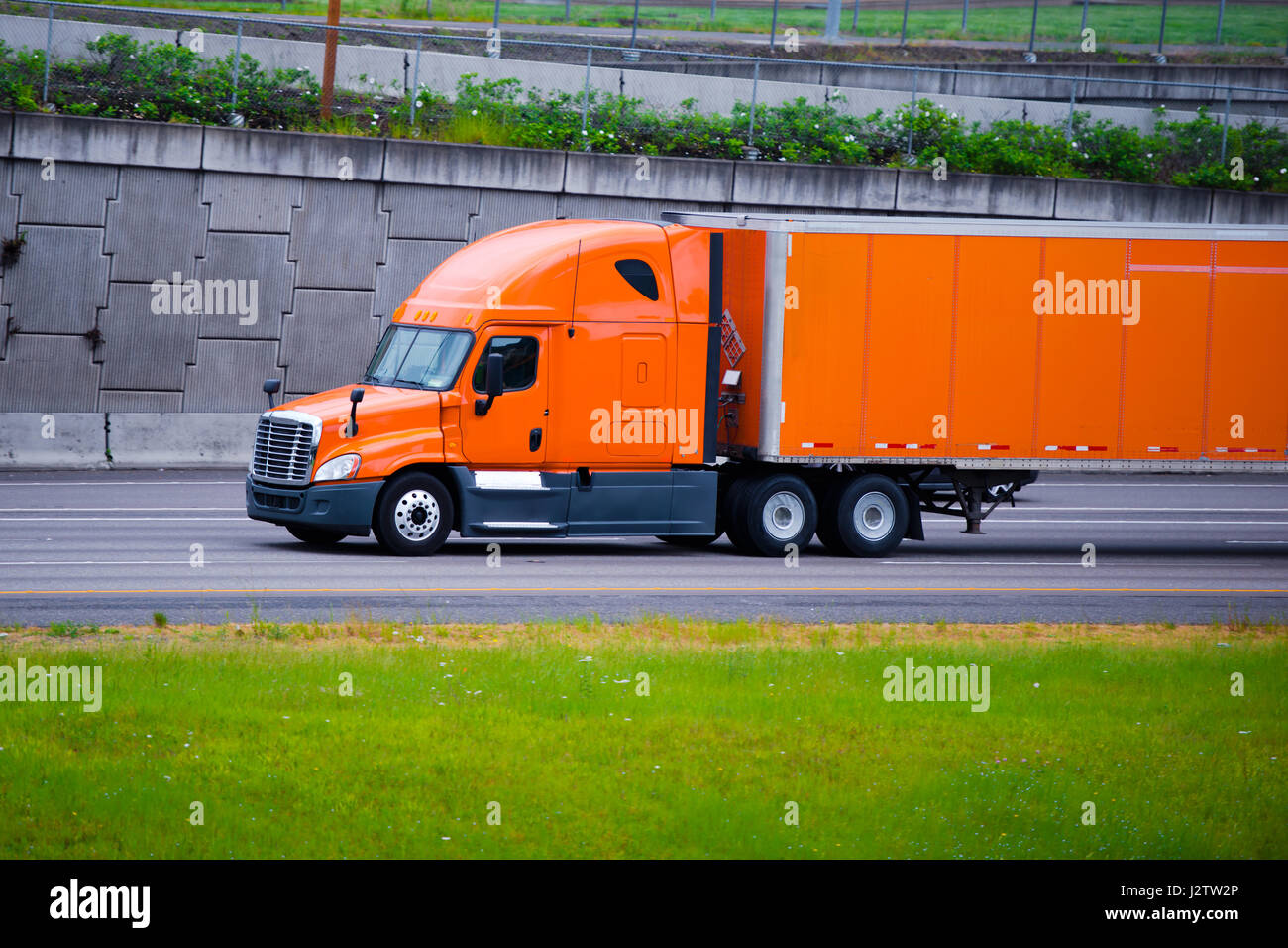 Modern long haul commercial cargo pro power bright orange big rig semi