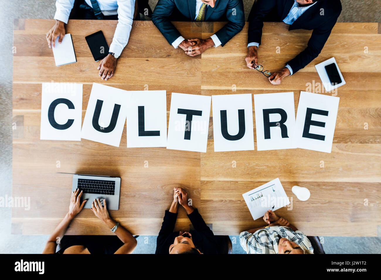 Top view of business people with word Culture on table. Business people having a meeting and discussing over work culture in office. Stock Photo