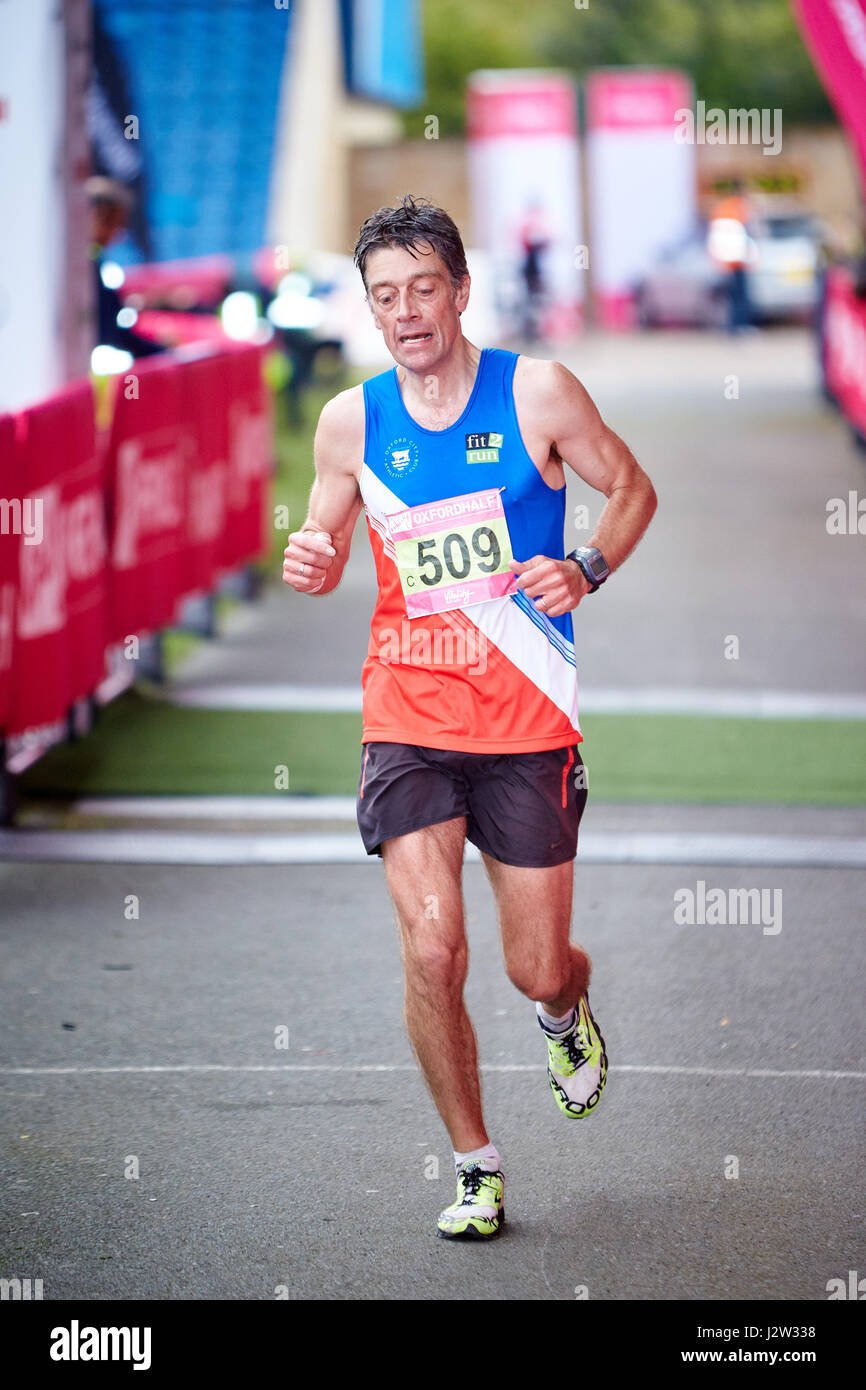 A runner crosses the finish line of the 2014 Oxford Half Marathon to