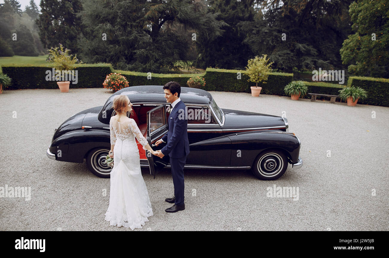 bride and groom standing in the yard near the car Stock Photo - Alamy