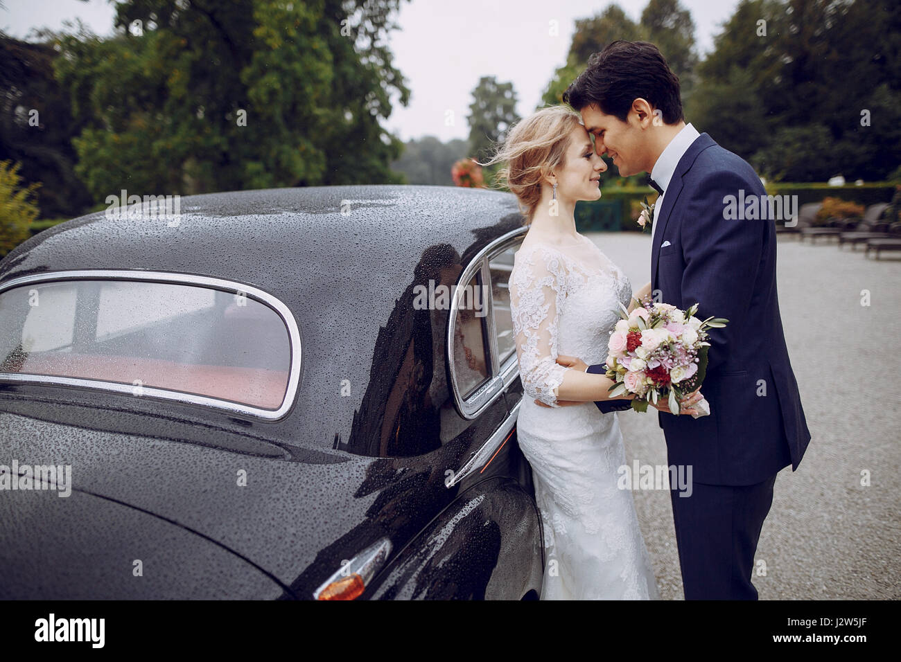 bride and groom standing in the yard near the car Stock Photo - Alamy