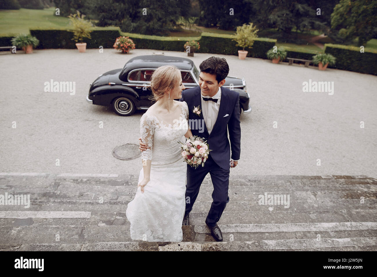 bride and groom standing in the yard near the car Stock Photo - Alamy