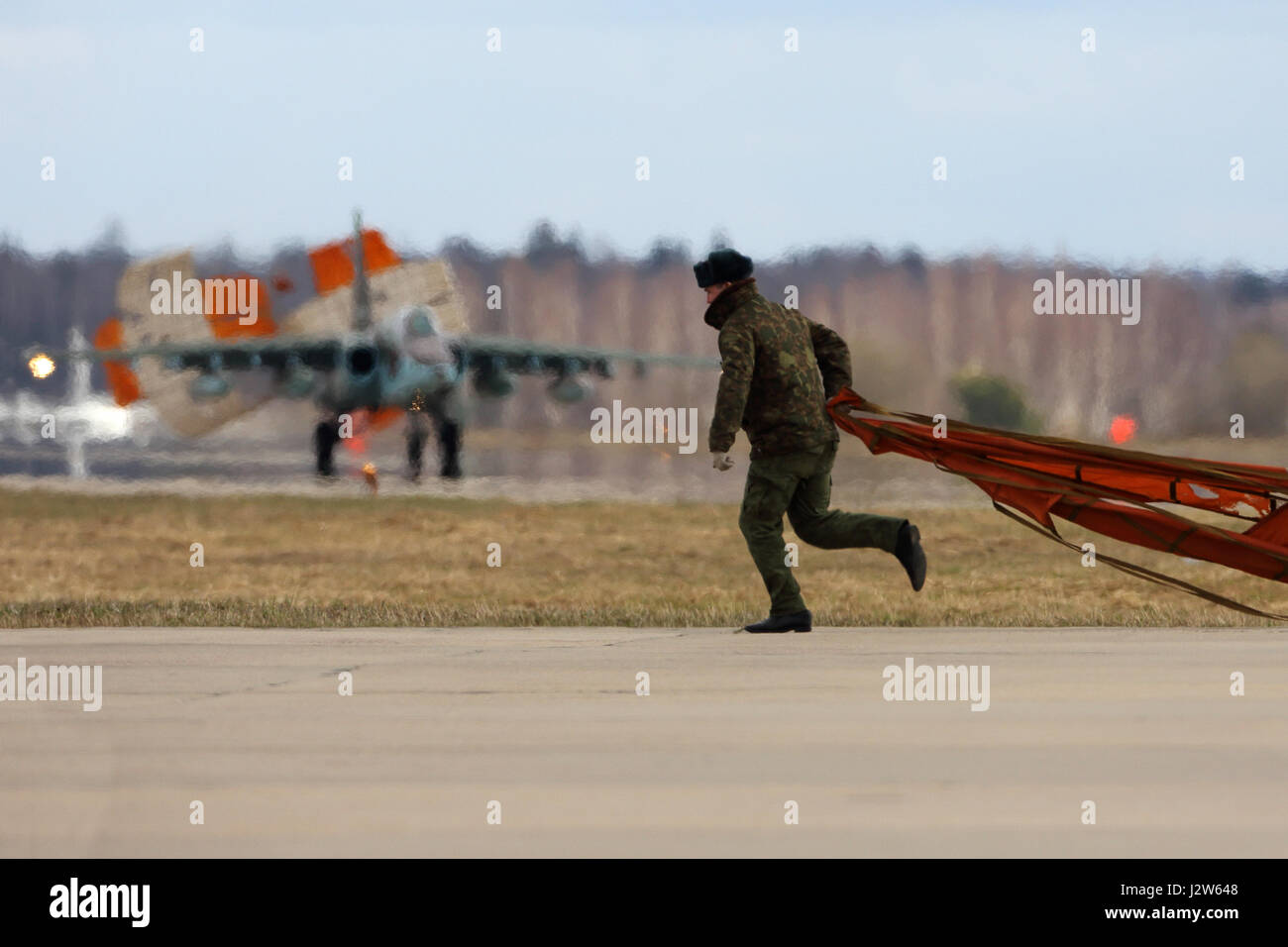 KUBINKA, MOSCOW REGION, RUSSIA - APRIL 24, 2017: Soldier picks up dropped parachute of Sukhoi Su-25 airplane of Russian air force during Victory Day p Stock Photo