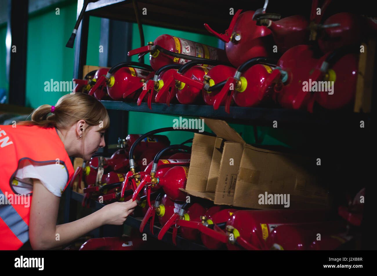 Checking fire extinguishers in the warehouse. Woman Engineer shall