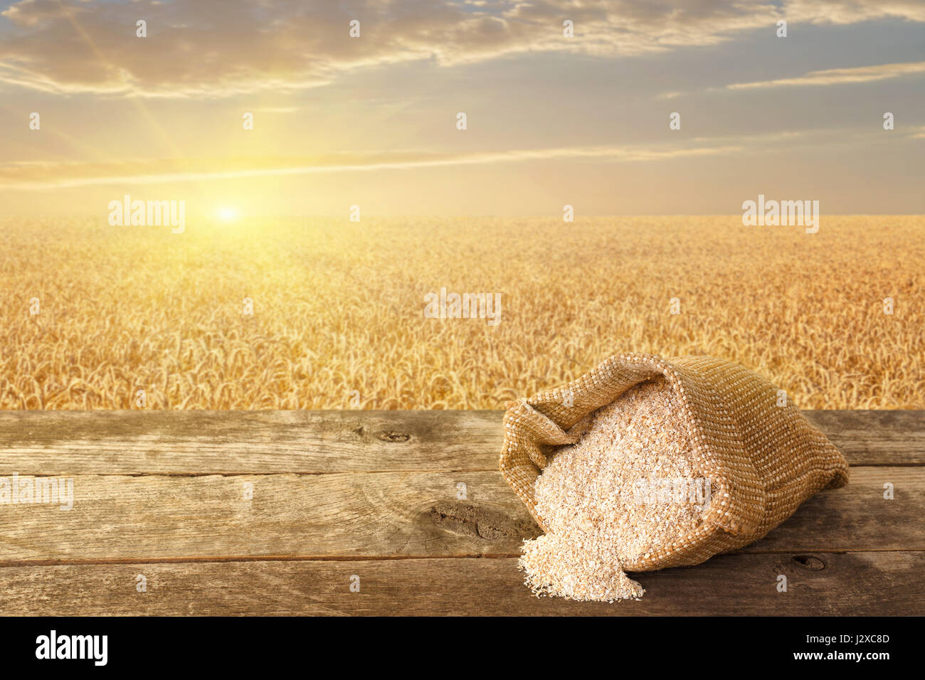 bran in sack on table with ripe cereal field on the background. Food supplement to improve digestion. Dietary fiber. Product for healthy nutrition and Stock Photo