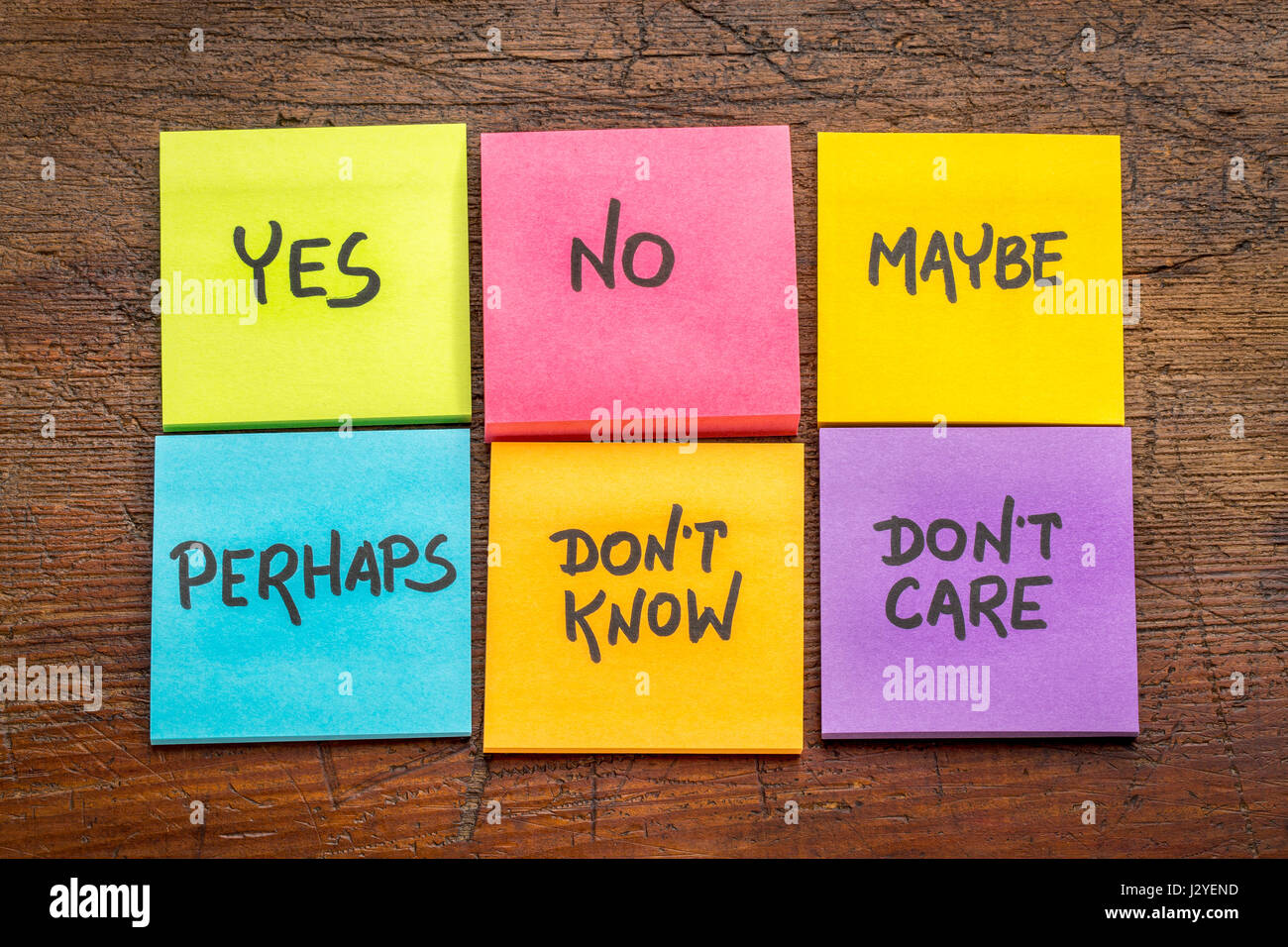 yes, no, maybe, perhaps, don't know, don't care -  undecided voter concept, colorful sticky notes against grunge rustic wood board Stock Photo