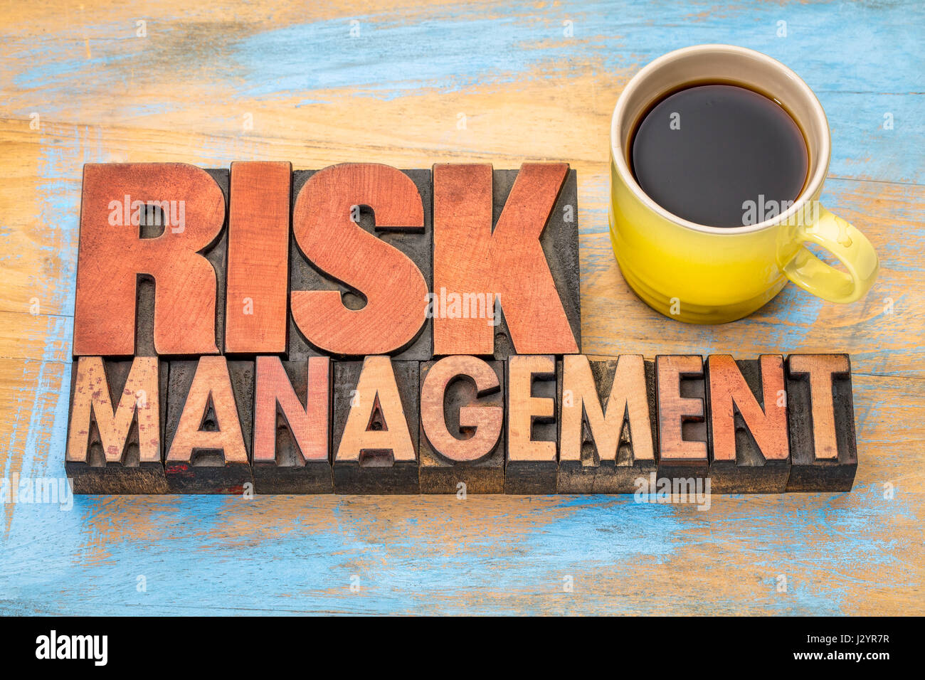 risk management banner in vintage letterpress wood type blocks with a cup of coffee Stock Photo