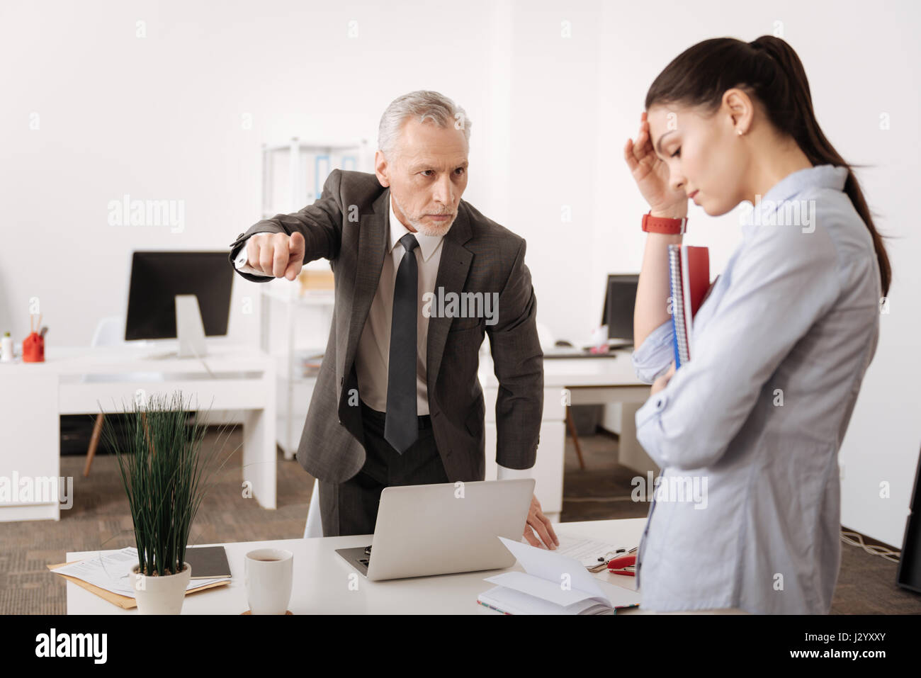 Angry boss standing opposite his secretary Stock Photo Alamy